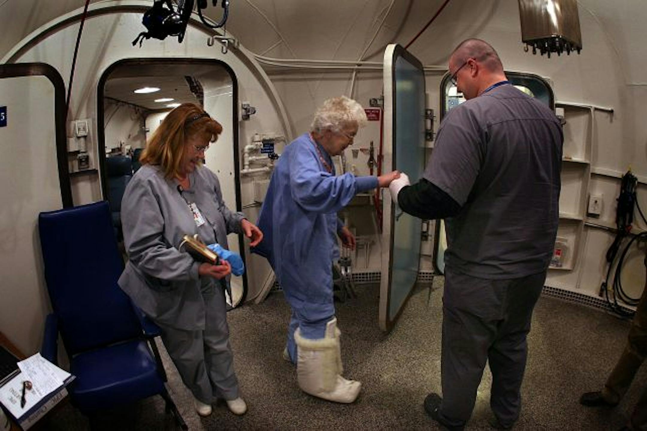 Nurse Ginny Nolting, left, and technician Joe Harris helped patient Eleanore Jenko following her treatment in Hennepin County Medical Center's hyperbaric chamber. The nearly-45-year-old facility had more than 3,300 treatments last year for 221 patients.