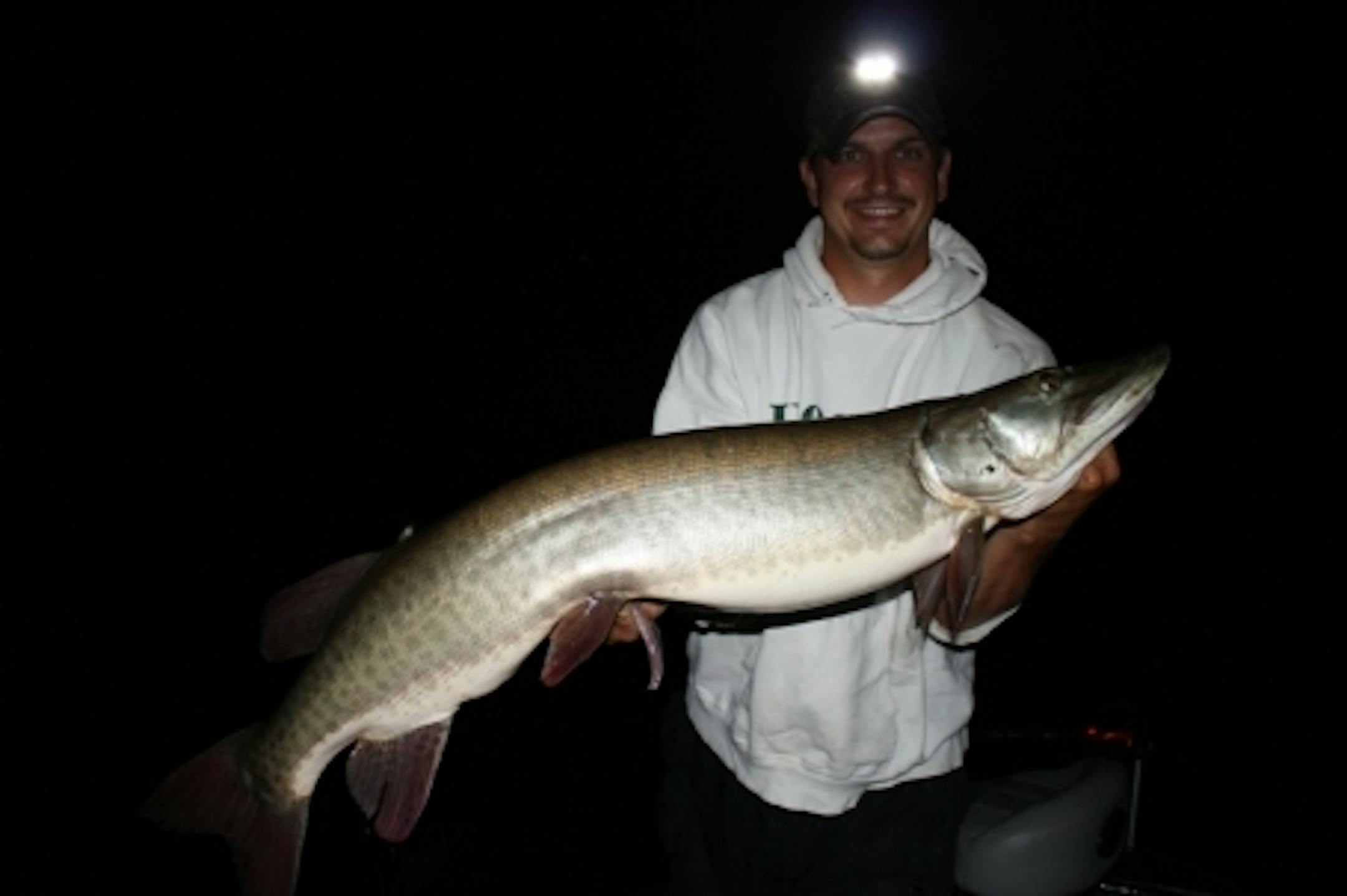 Matt Hennen proudly hoists his big muskie caught while fishing with the author, Travis Frank