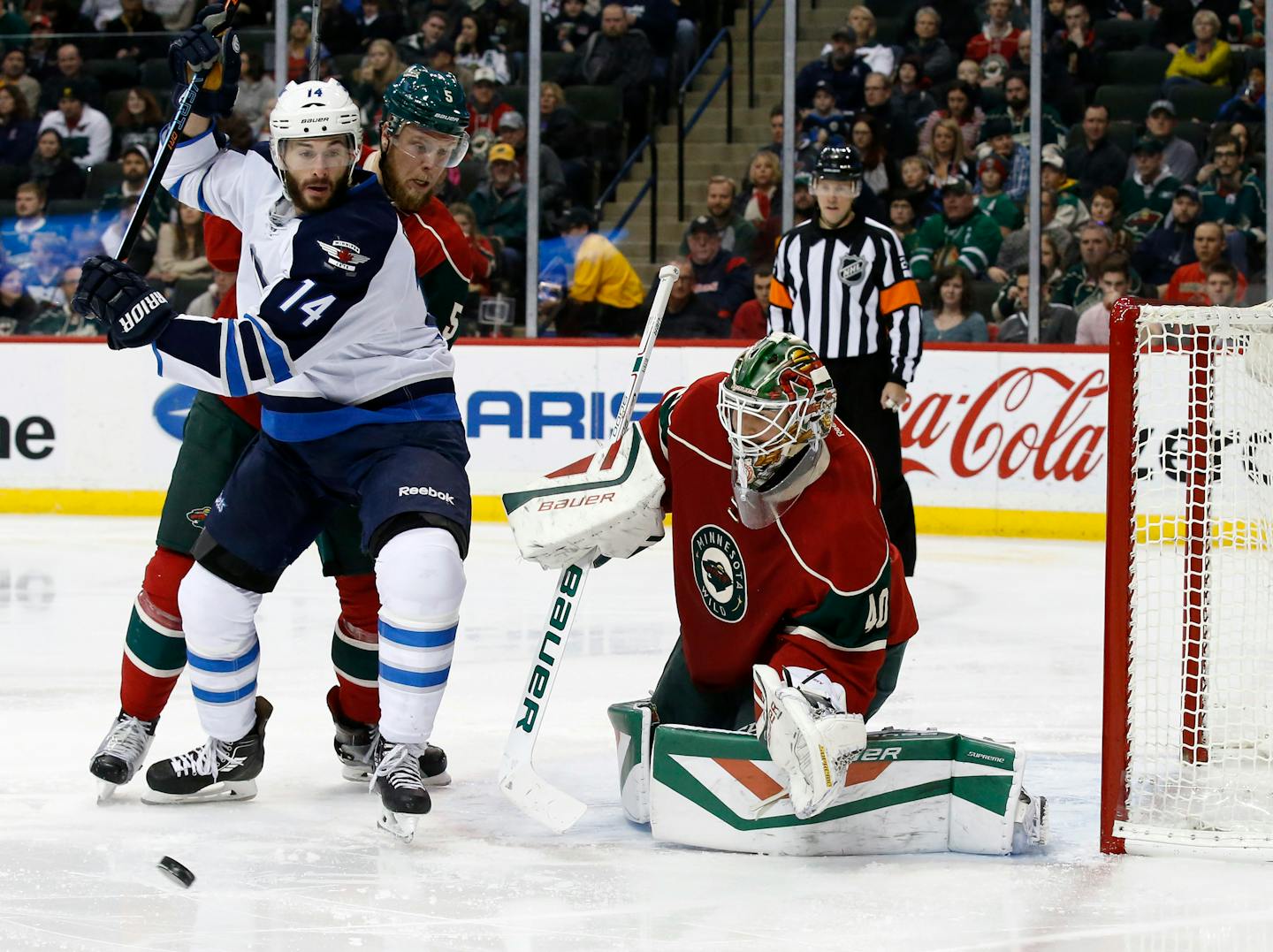 A shot goes wide past Minnesota Wild goalie Devan Dubnyk, front right, Wild defenseman Christian Folin (5), of Sweden, and Winnipeg Jets right wing Anthony Peluso (14) during the second period of an NHL hockey game in St. Paul, Minn., Friday, Nov. 27, 2015.