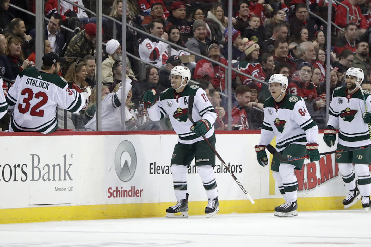 Minnesota Wild left wing Zach Parise, center, celebrates his second period goal against the New Jersey Devils during an NHL hockey game, Saturday, Feb. 9, 2019, in Newark, N.J. (AP Photo/Julio Cortez)