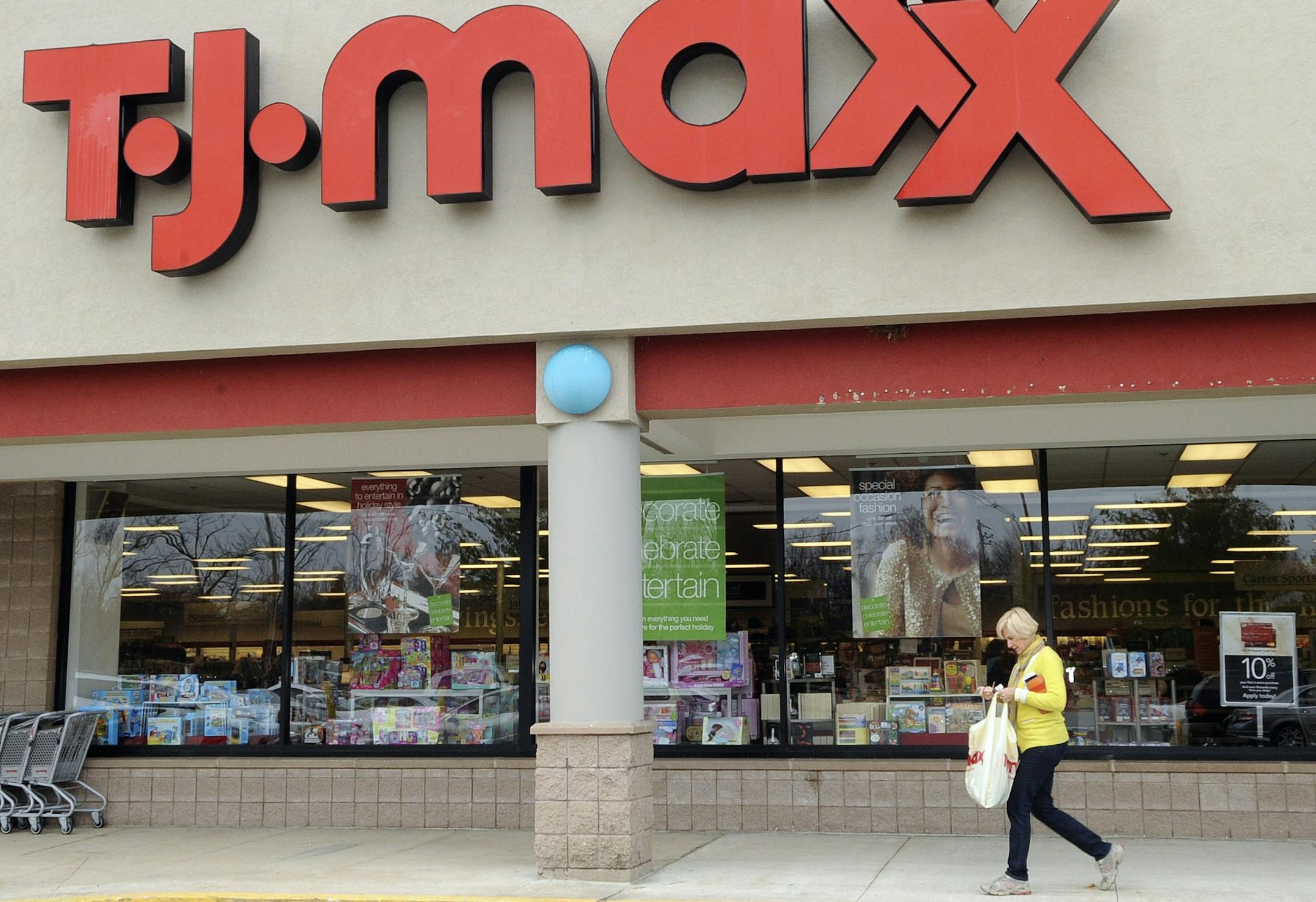 FILE - In this Nov. 17, 2009 file photo, a customer walks past a T.J. Maxx store in Boston. TJX Cos., the owner of T.J. Maxx, Marshalls and Home Goods stores, on Wednesday, Feb. 25, 2015 said it will boost pay for U.S. workers to at least $9 per hour. (AP Photo/Lisa Poole, File)