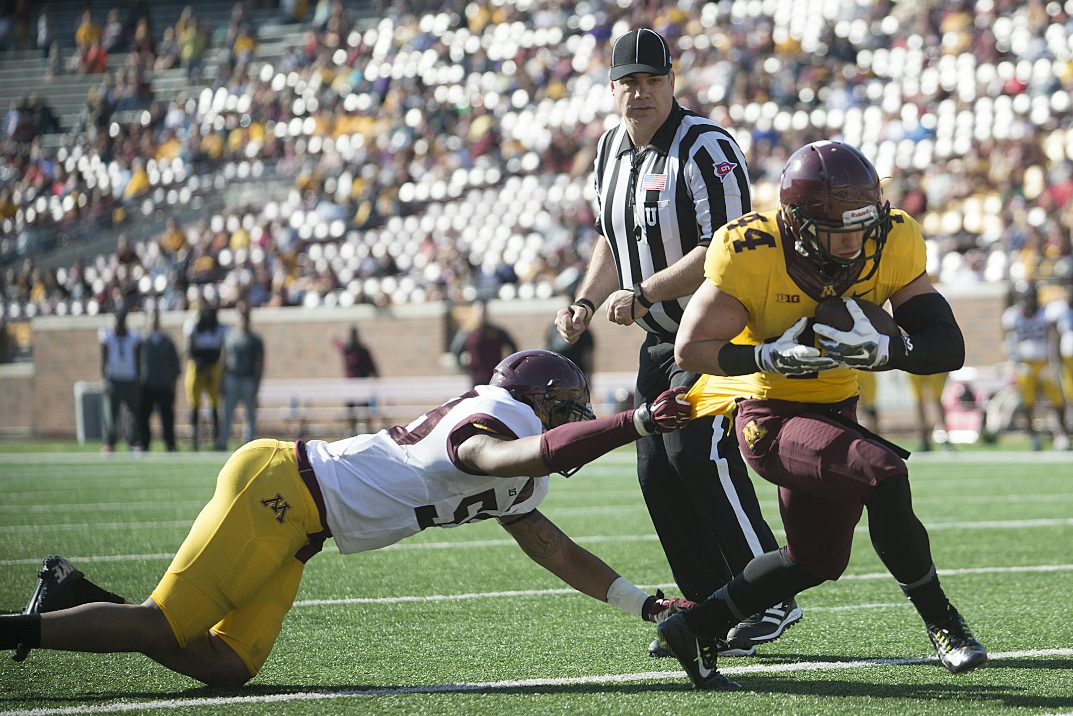 University of Minnesota running back Jacob Kirsch (44) breaks a tackle attempt by linebacker Ray Dixon (59) for a touchdown in the second half of Saturday's spring game last year.