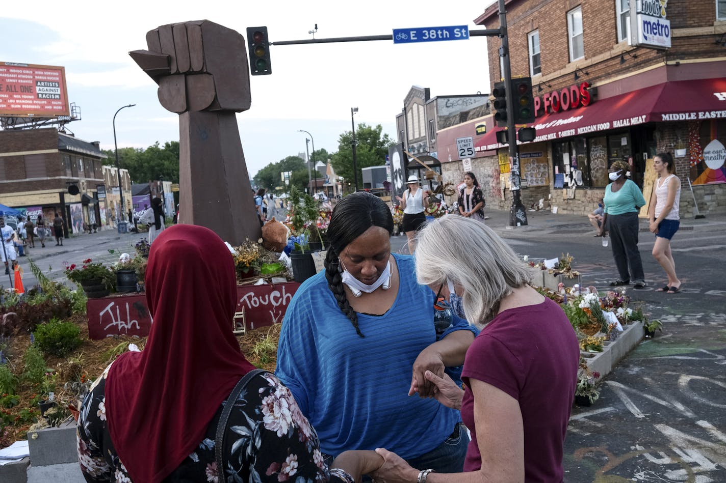 A prayer circle at 38th Street and S. Chicago Avenue in Minneapolis, the intersection where George Floyd was killed. Plans to reopen the area are beginning to take shape.