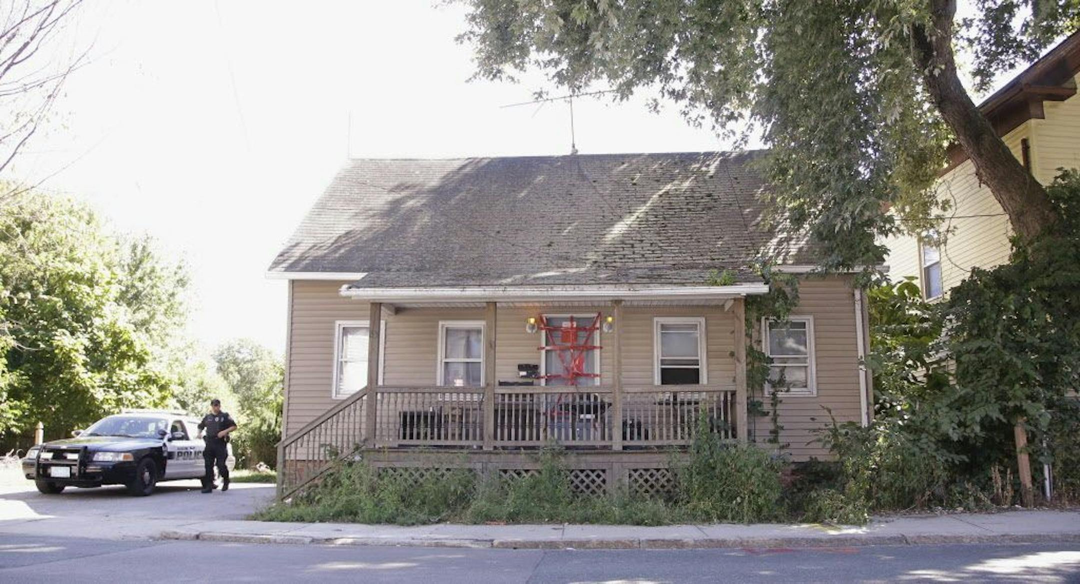 A Blackstone police officer stands post outside a house where a Massachusetts prosecutor said the bodies of three infants were found Thursday in Blackstone, Mass., Friday, Sept. 12, 2014.