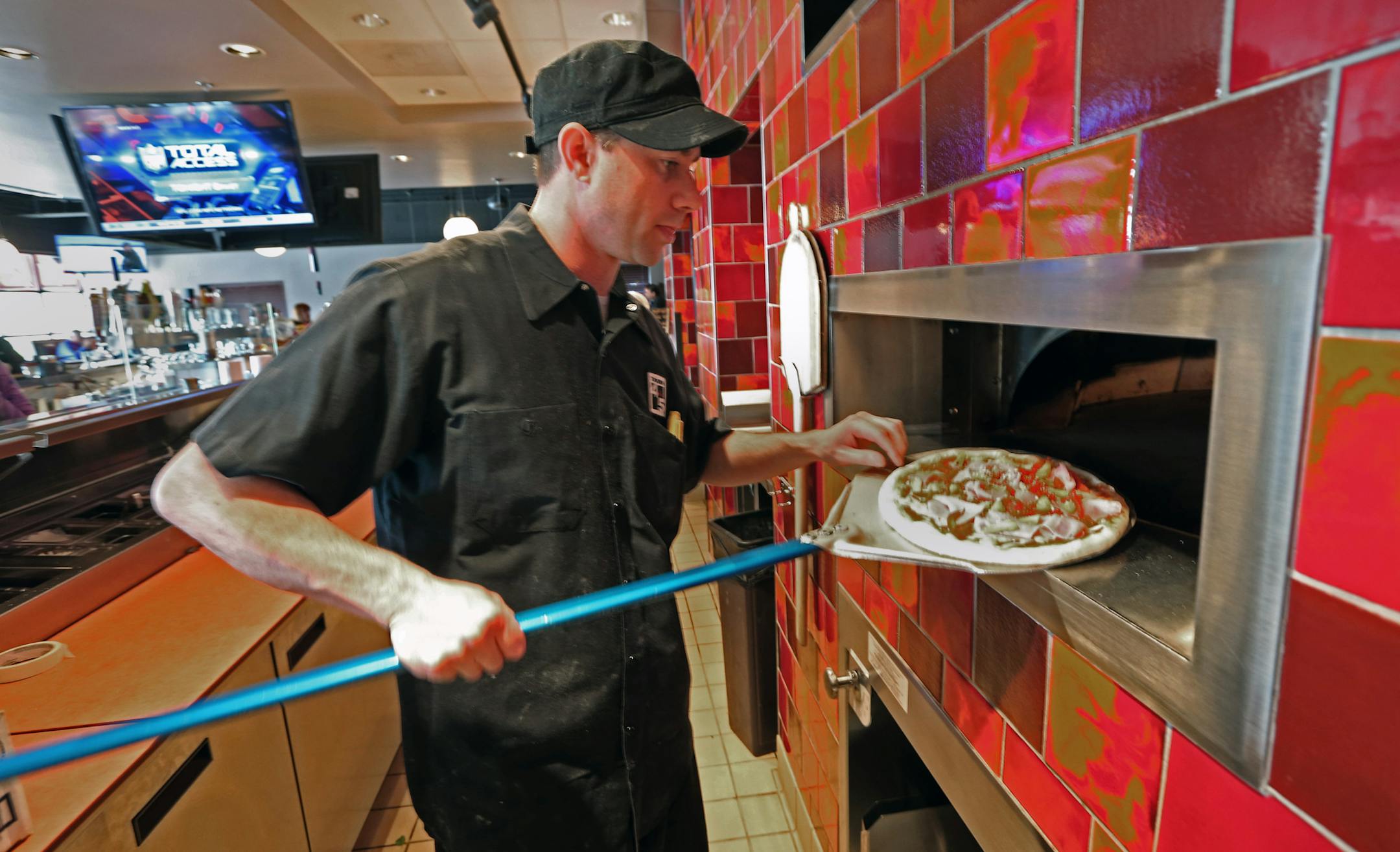 Brendan Hanson put a pizza into the wood burning oven at Tavern 4+5, 16396 Wagner Way, just off Hwy 5 in Eden Prairie. Photographed on 11/1/13.] Bruce Bisping/Star Tribune bbisping@startribune.com Brendan Hanson/source.
