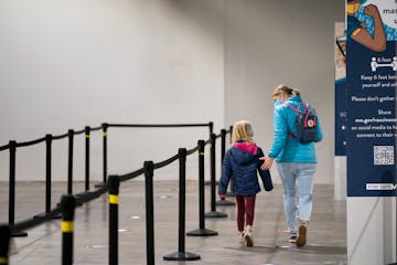 Anya Eckroth, 7, and her mom Kate Eckroth waited in line Wednesday for Anya’s COVID vaccine at the Mall of America.