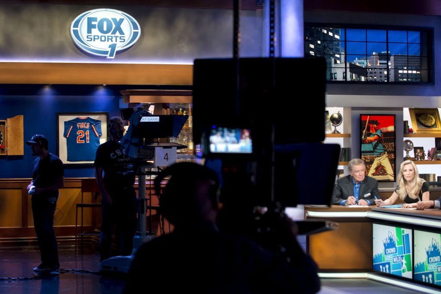 FILE -- From right: Georgie Thompson, and Regis Philbin on the set for the new FOX Sports 1 show "Crowd Goes Wild" in New York, Aug. 9, 2013.