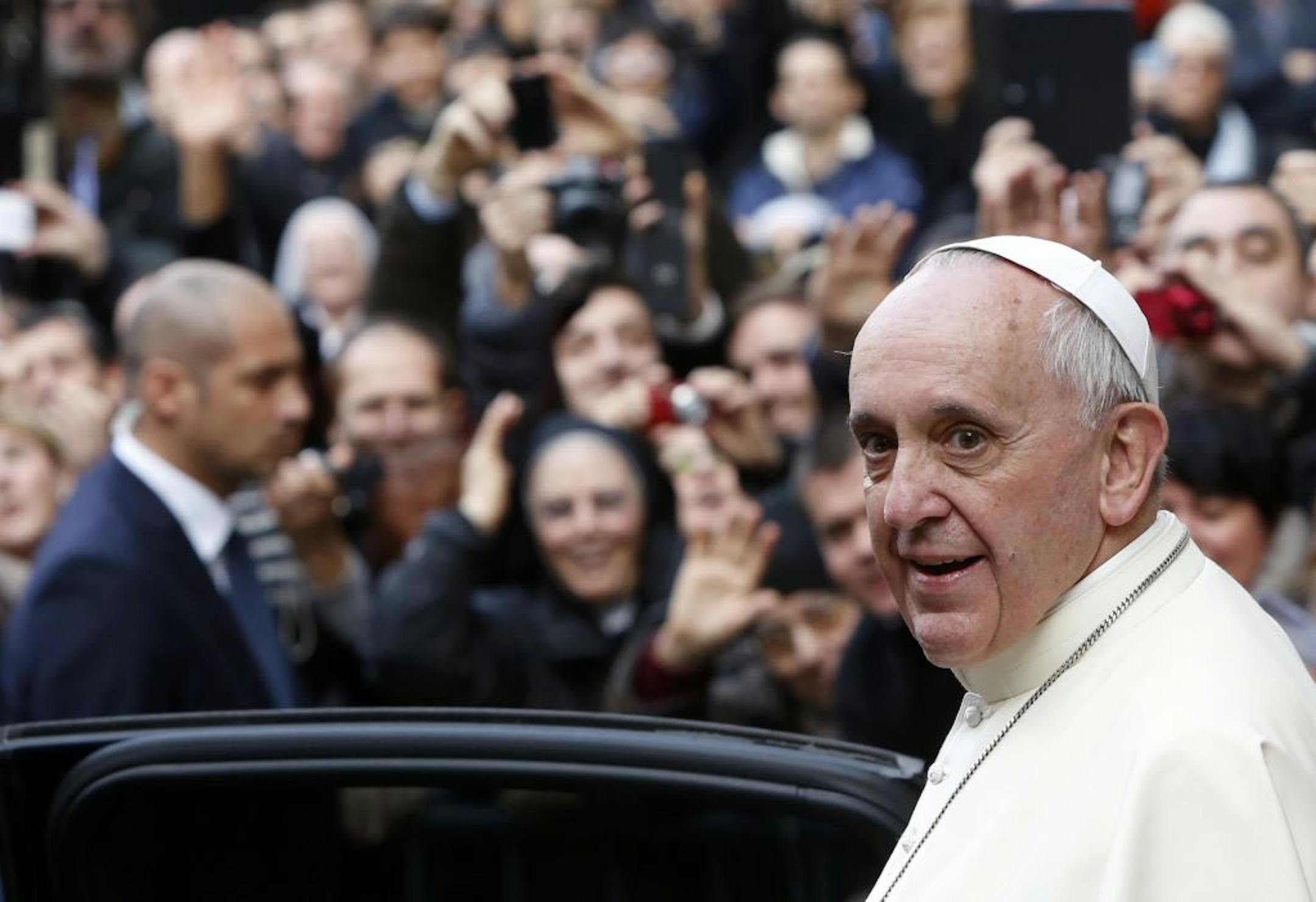 Pope Francis smiles as he leaves Rome's Jesus' Church to celebrate a mass with the Jesuits, on the occasion of the order's titular feast, Friday, Jan. 3, 2014.