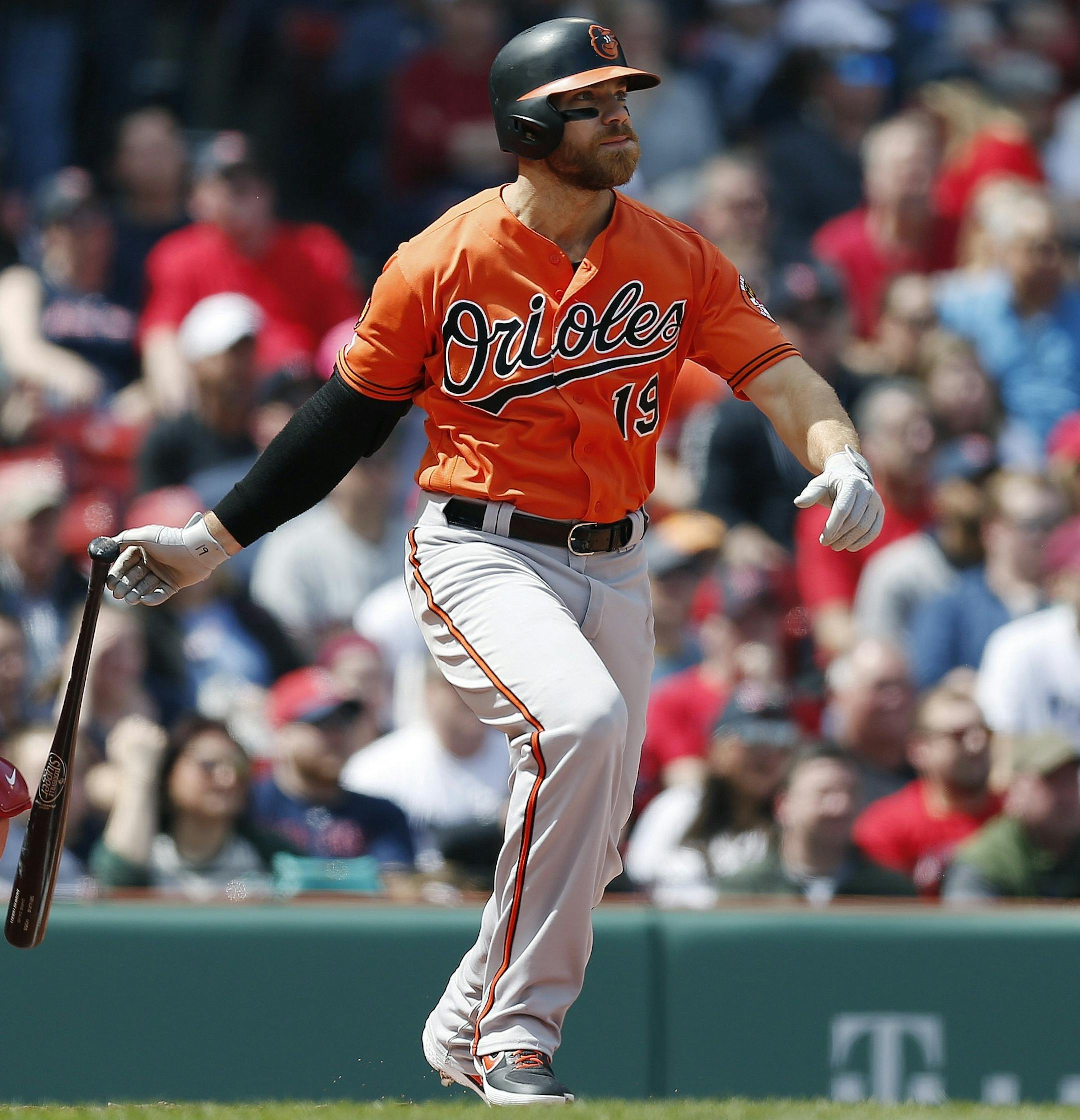 Baltimore Orioles' Chris Davis watches his two-run single in front of Boston Red Sox's Christian Vazquez during the first inning of a baseball game in Boston, Saturday, April 13, 2019. (AP Photo/Michael Dwyer)