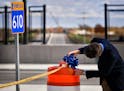 John Hagen, transportation operations engineer for Maple Grove fixed a blue bow to the end of a ribbon to be cut to celebrate the upcoming completion 