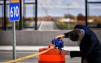 John Hagen, transportation operations engineer for Maple Grove fixed a blue bow to the end of a ribbon to be cut to celebrate the upcoming completion 