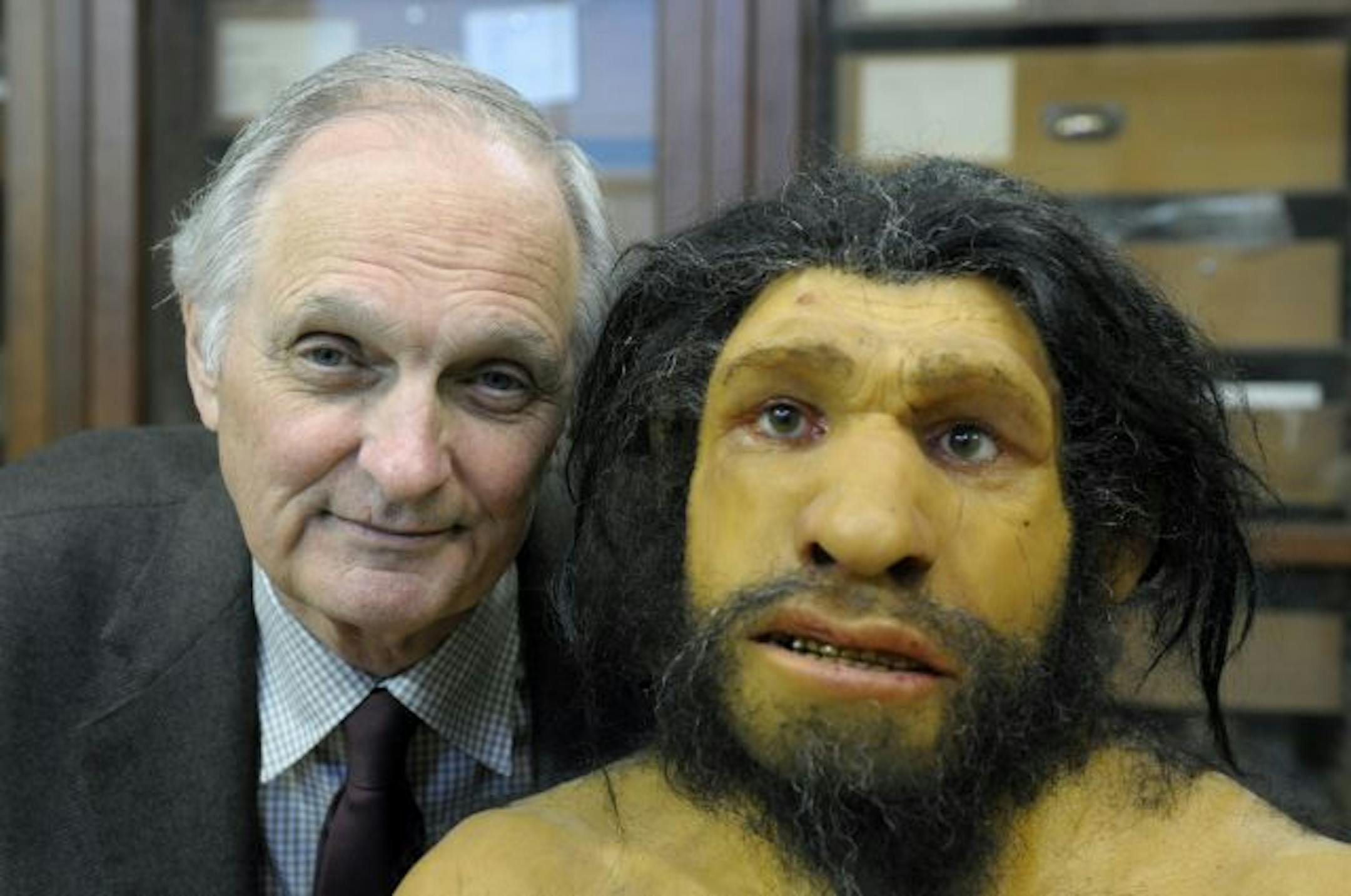 Alan Alda, host of the PBS series "The Human Spark," poses with a representation of a Neanderthal in this undated handout photo.