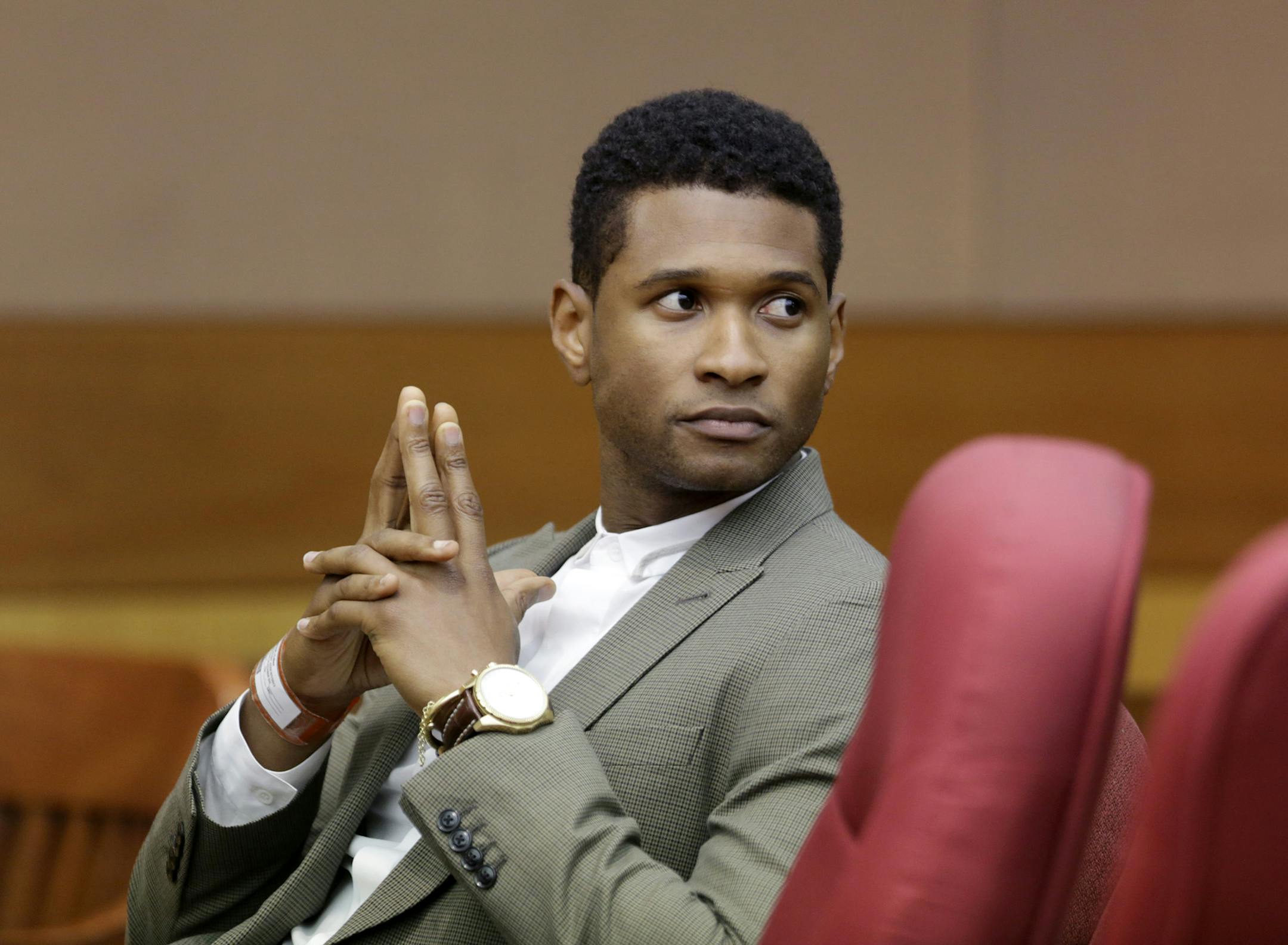 R&B singer Usher waits for a child custody hearing to begin, Friday, Aug. 9, 2013, in Atlanta. A judge in Atlanta is set to hear arguments in the child custody battle between Usher and his ex-wife. Tameka Foster Raymond requested the hearing earlier this week after the former couple's son got caught in a pool drain while in the care of Usher's aunt. (AP Photo/David Goldman)