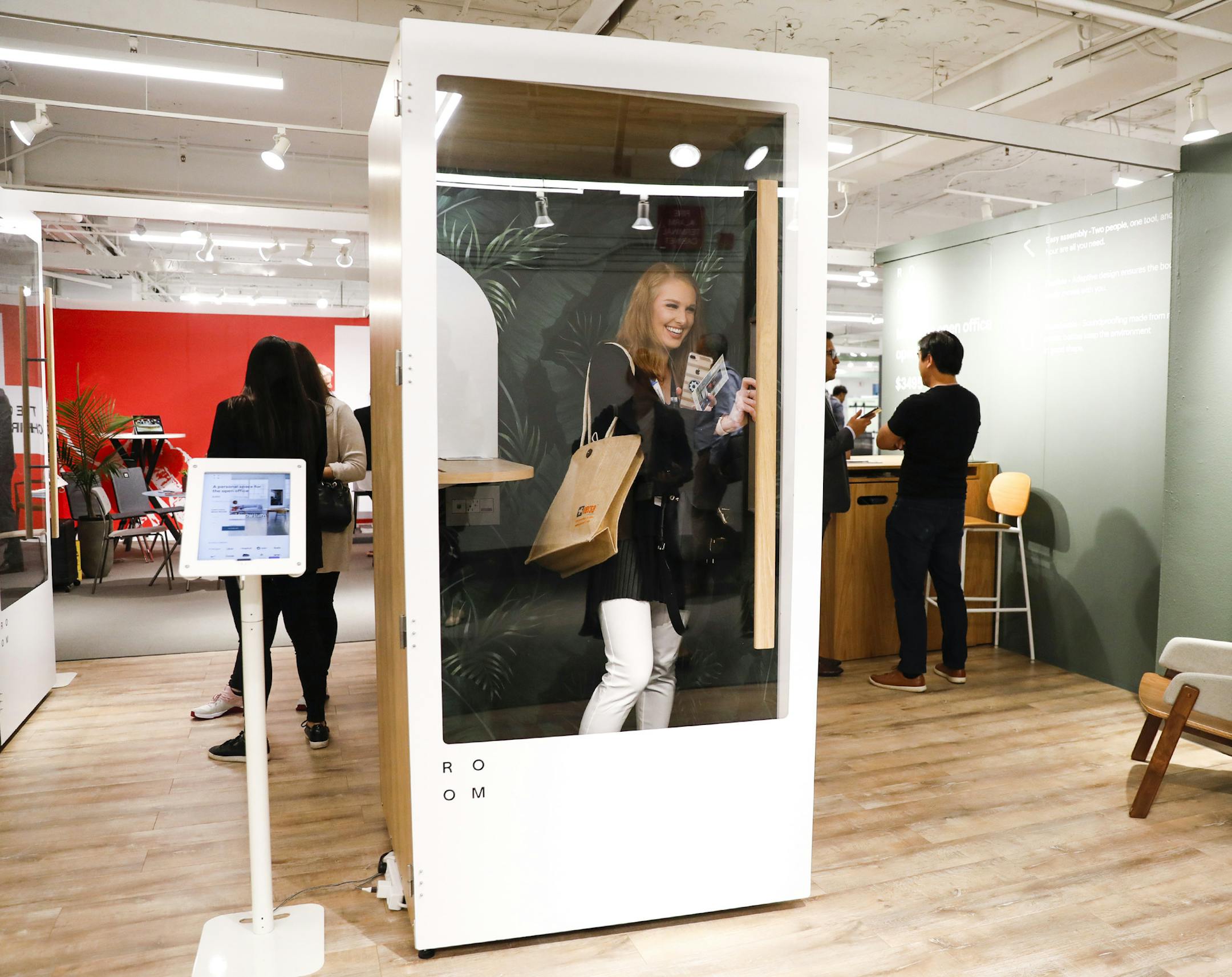 Gabriella Massey, a junior interior designer with Bailey Edward, takes a peek at a phone booth by ROOM on the 7th floor at NeoCon being held at the Merchandise Mart on Monday, June 10, 2019. A new trend in offices are phone booth-like spaces that create a sense of privacy for employees as opposed to the open floor office trend that has been popular. (Jose M. Osorio/Chicago Tribune/TNS) ORG XMIT: 1341900