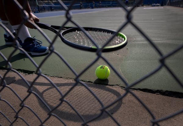 A player picked up a ball with her racket during matches between Blake vs. Minnetonka High Schools.