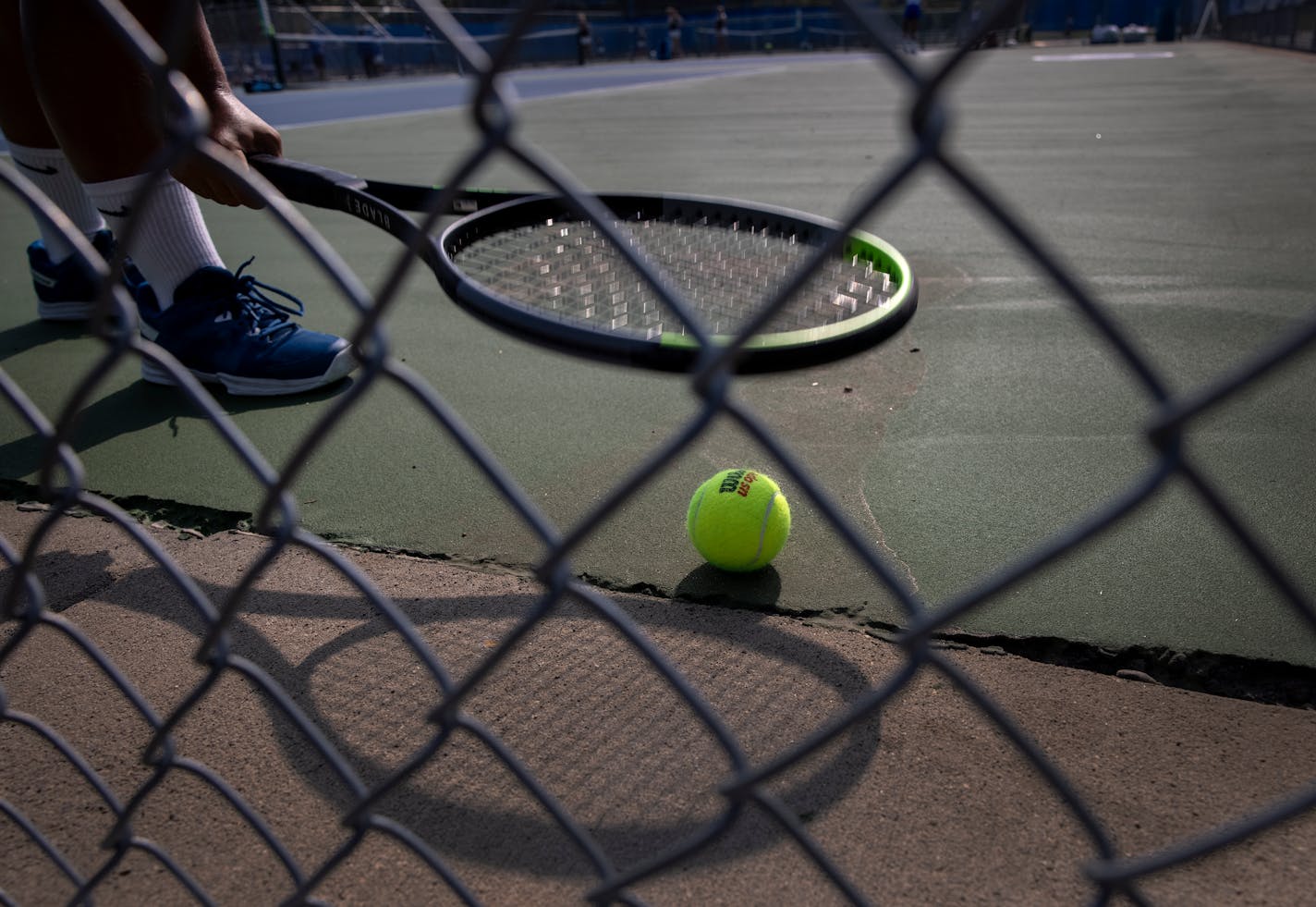 A player picked up a ball with her racket during matches between Blake vs. Minnetonka High Schools.