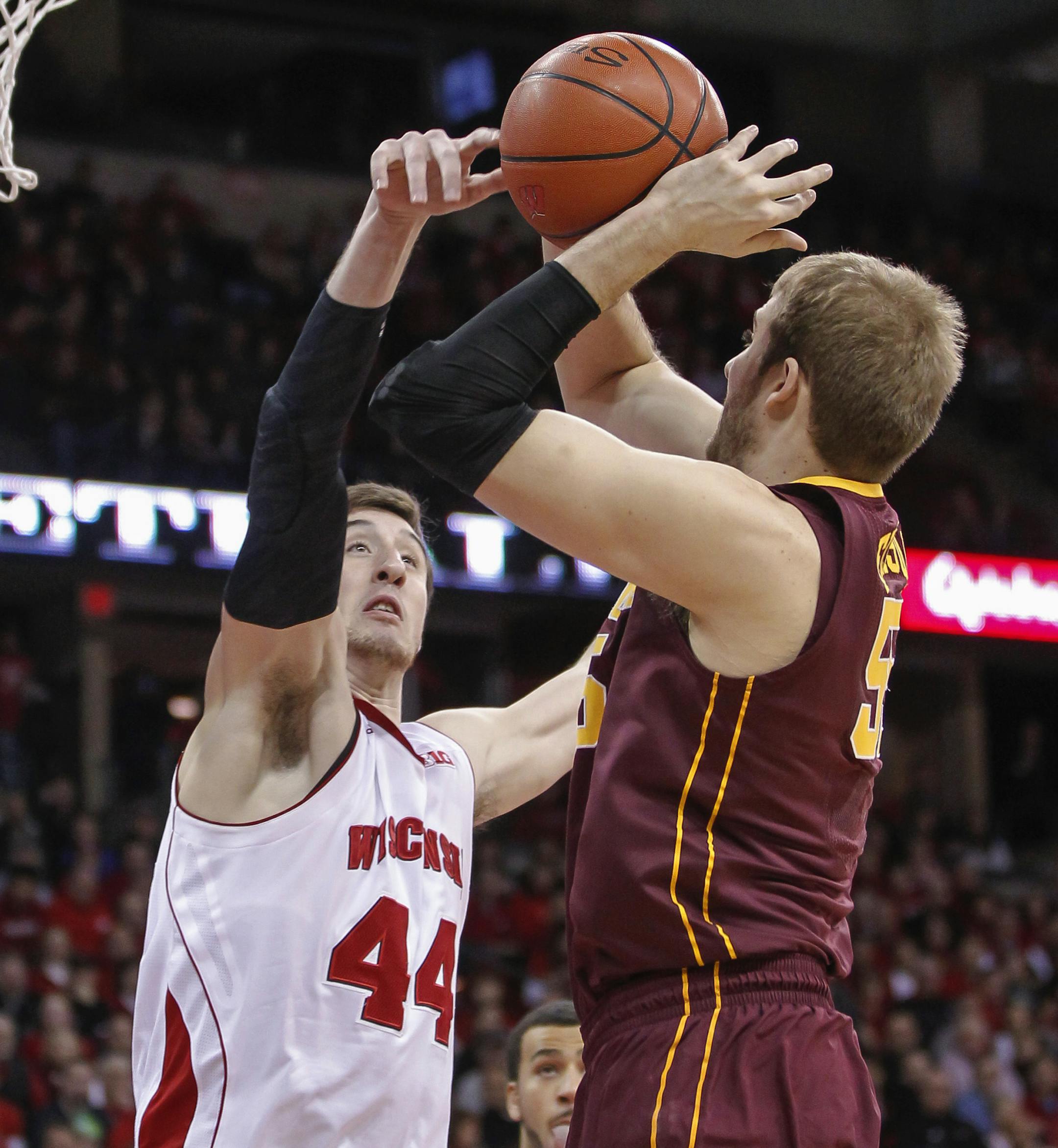 Minnesota's Elliott Eliason, right, shoots against Wisconsin's Frank Kaminsky during the first half of an NCAA college basketball game Thursday, Feb. 13, 2014, in Madison, Wis. (AP Photo/Andy Manis)