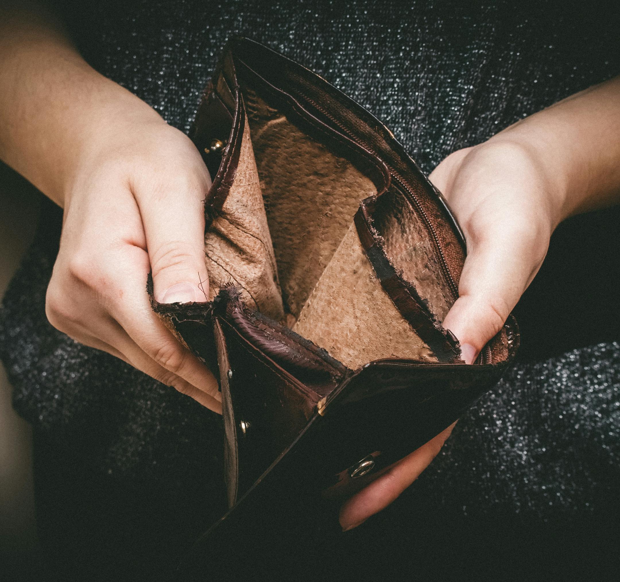 Old empty wallet in the hands .Vintage empty purse in hands of women . Poverty concept, Retirement. Special toning