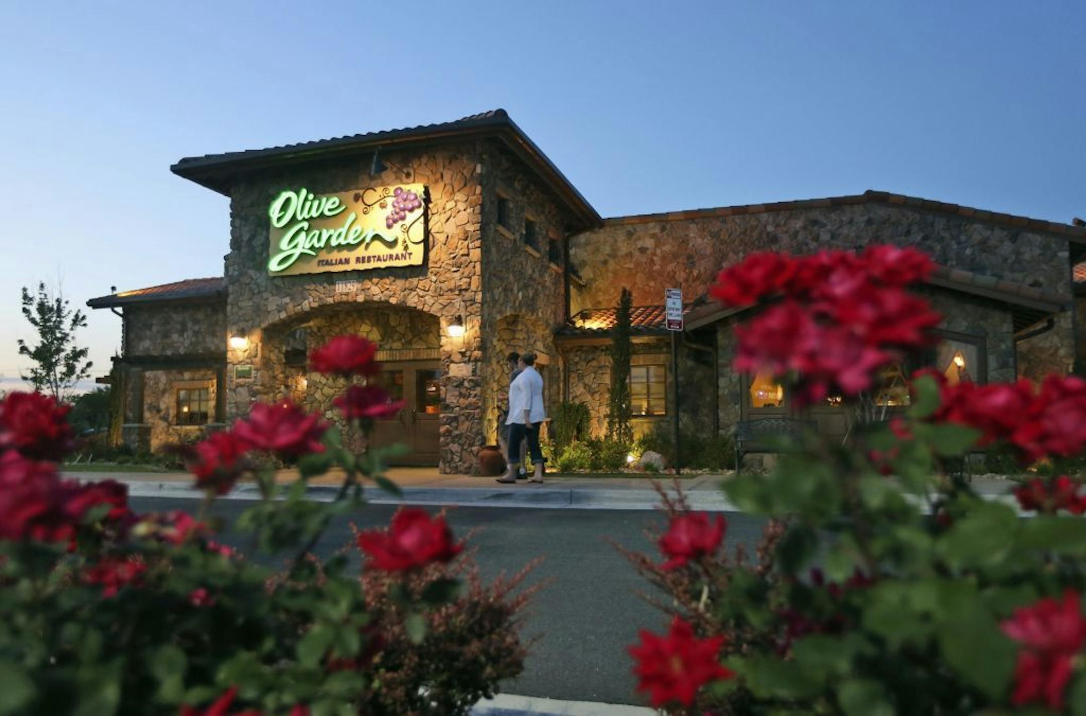 In this May 22, 2014 photo, patrons enter an Olive Garden Restaurant in Short Pump, Va. Olive Garden is hurting itself by piling on too many breadsticks, according to an investor that's disputing how the restaurant chain is run.
