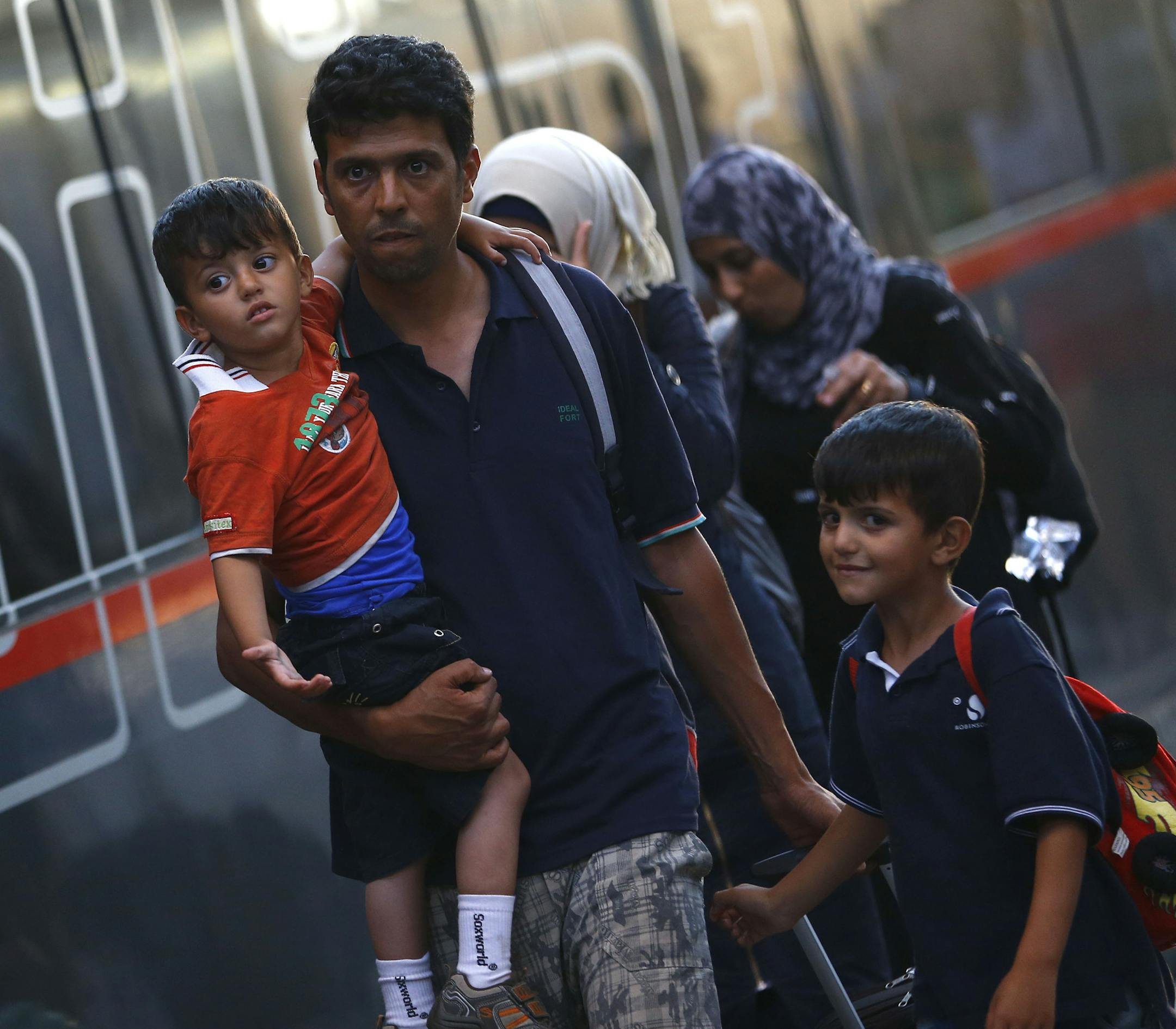 Migrants disembark from a train coming from Austria at the main station in Munich, Germany, Monday, Aug. 31, 2015. Some hundreds of migrants are arriving in Munich on Monday, after making perilous journeys into Europe. (AP Photo/Matthias Schrader)