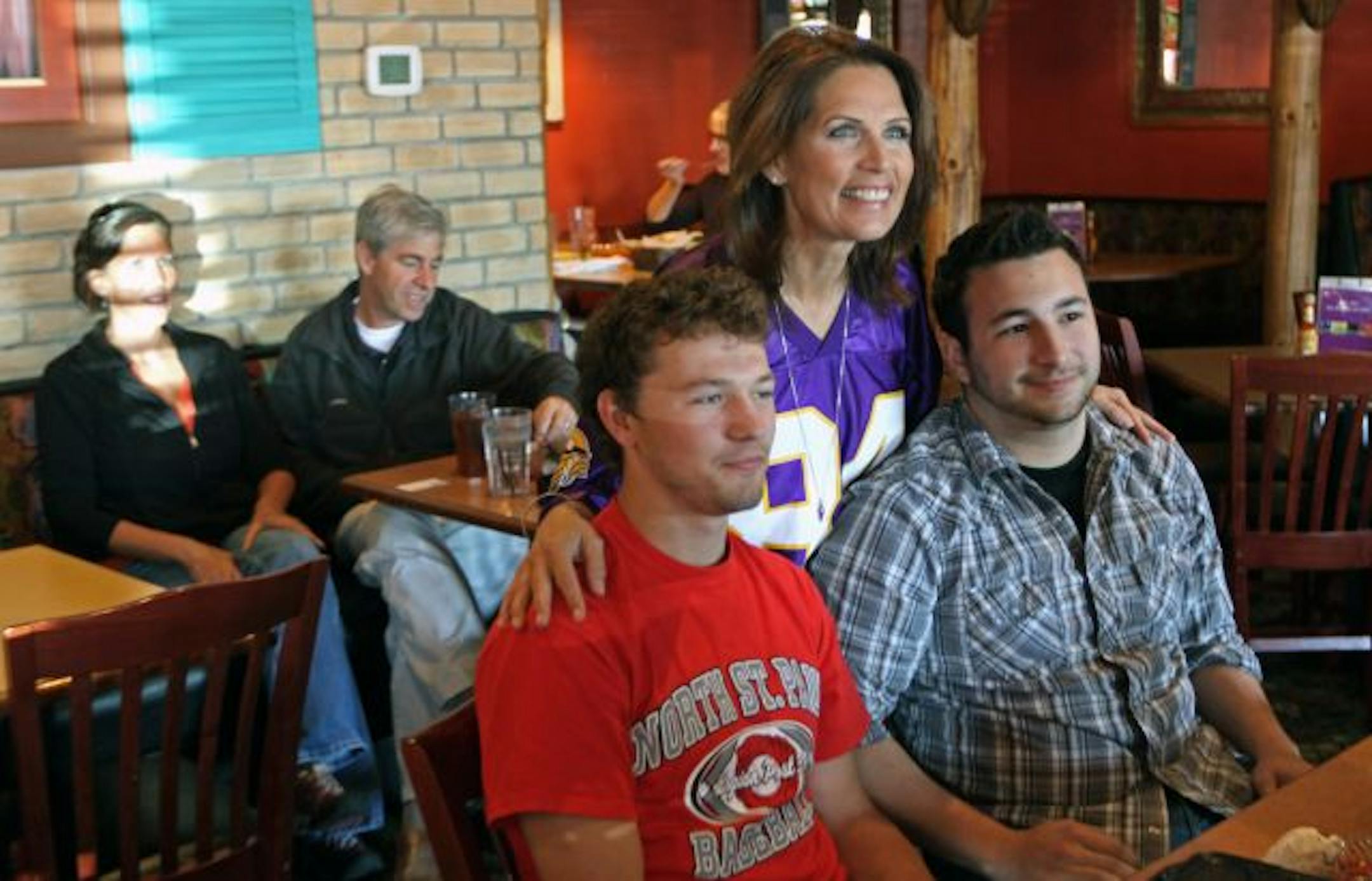 Joe Bruchul, left, of Lake Elmo and Jake McCants of Woodbury had their picture taken with Rep. Michele Bachmann on Wednesday as she met with supporters at the Acapulco restaurant in Woodbury.