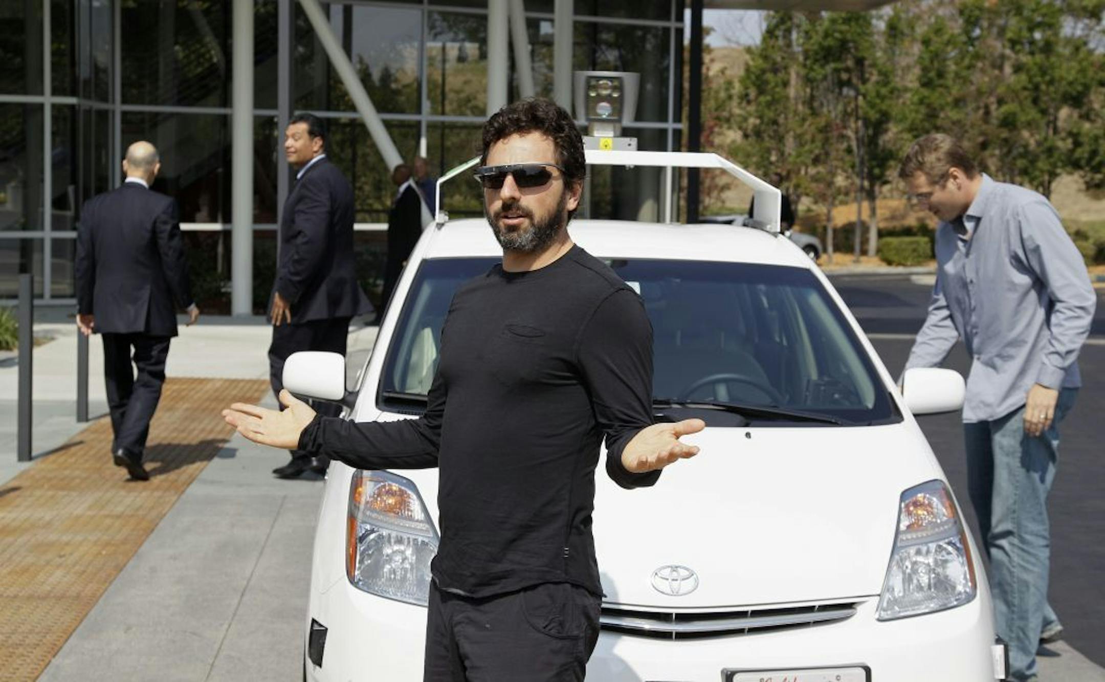 FILE - In this Sept. 25, 2012, file photo, Google co-founder Sergey Brin gestures after riding in a driverless car with officials, to a bill signing for driverless cars at Google headquarters in Mountain View, Calif.