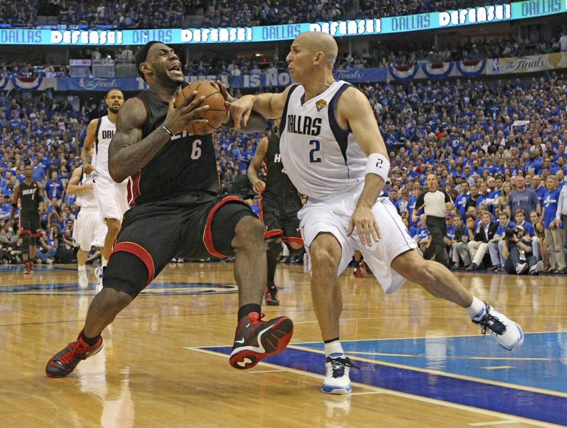 The Miami Heat's LeBron James, left goes to the basket against the Dallas Mavericks' Jason Kidd during the fourth quarter in Game 5 of the NBA Finals.
