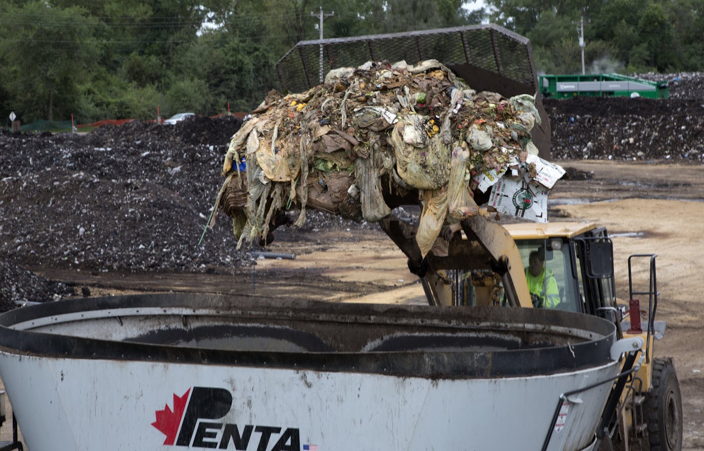 A fresh load of organic food waste is dumped into a mixing bin to begin the process of creating compost.