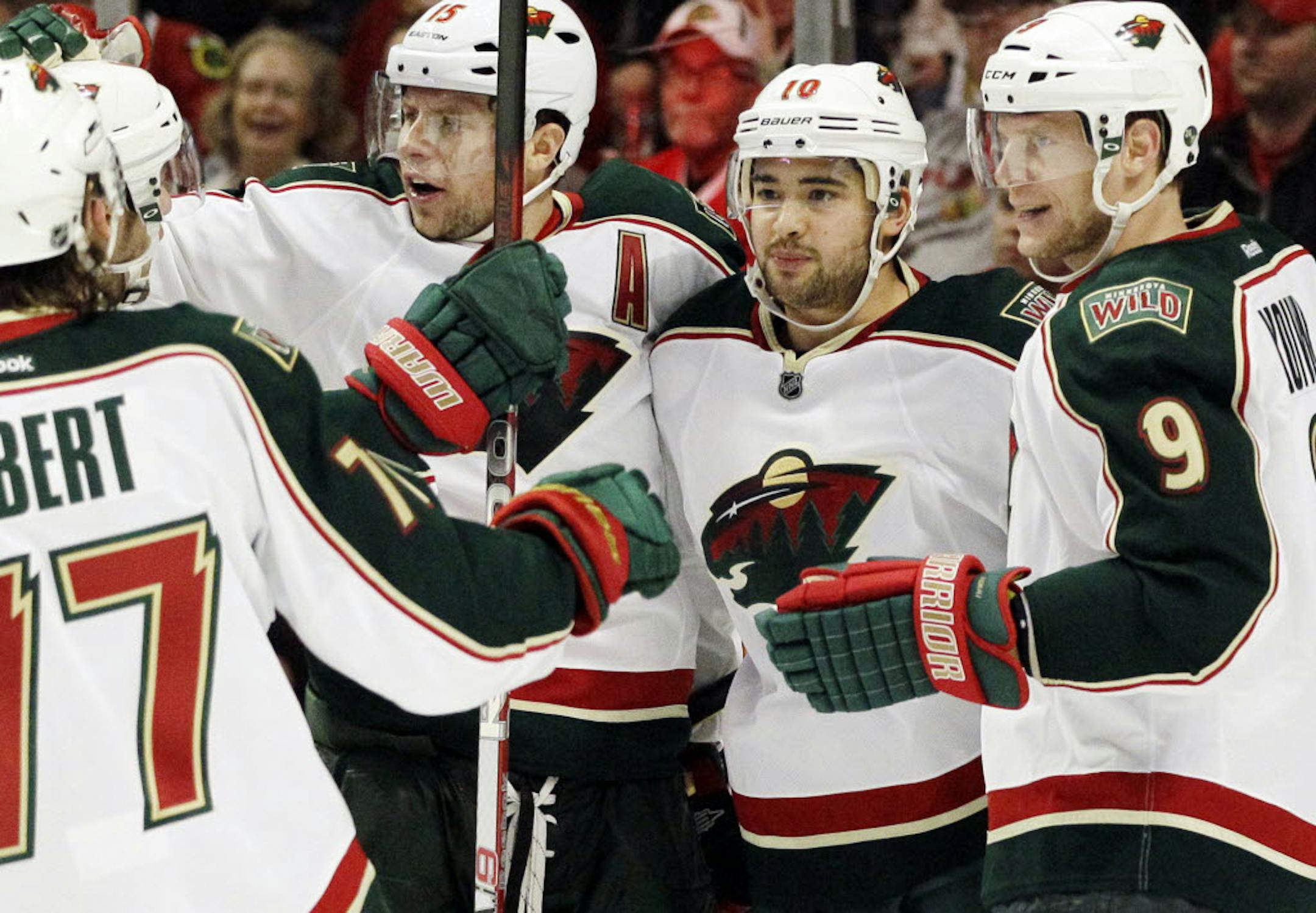 Minnesota's Devin Setoguchi (10) celebrates with Mikko Koivu (9) and Dany Heatley (15) after scoring during the first period against Chicago.