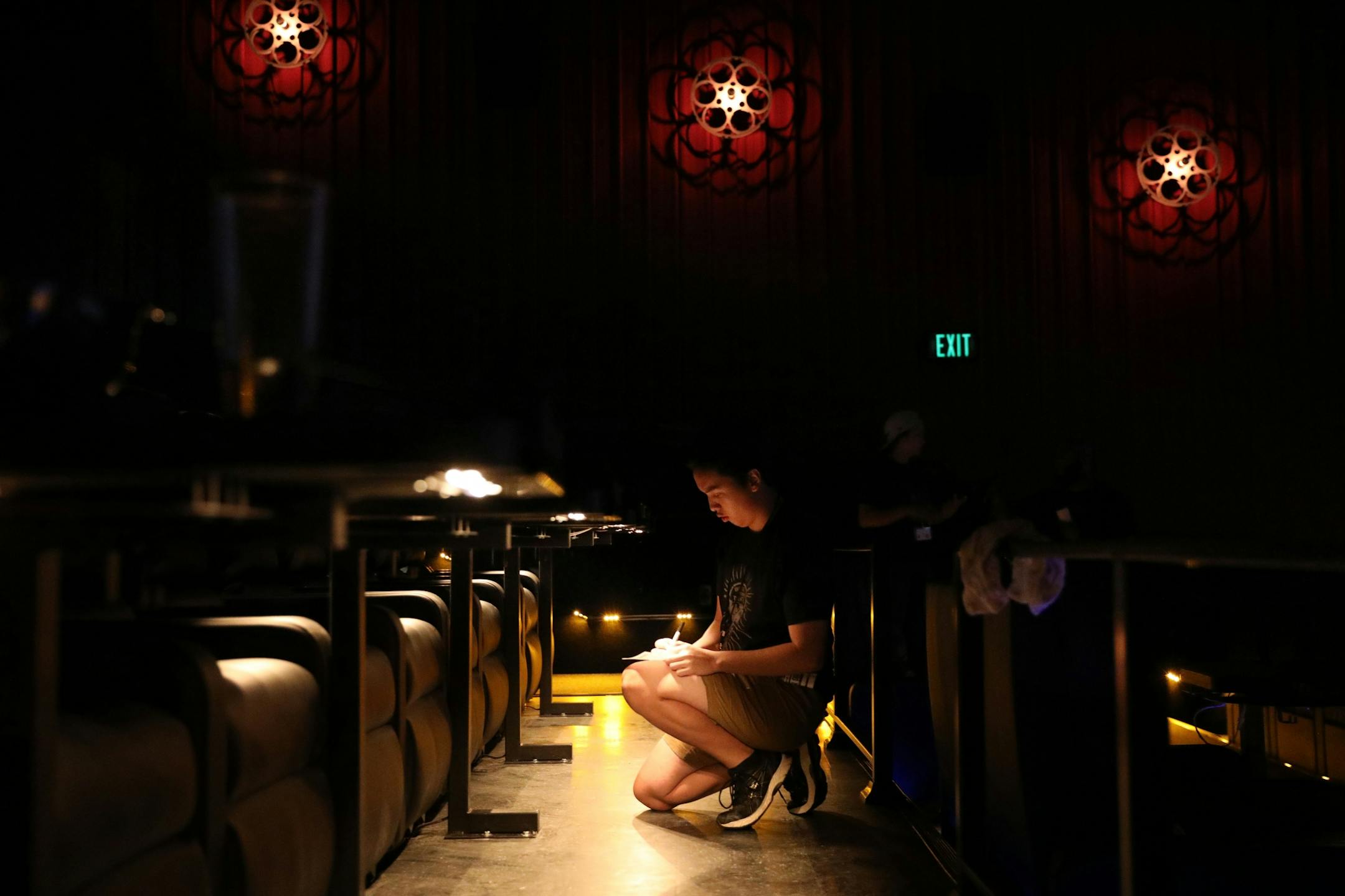 Staff practiced ducking past moviegoers and crouching to take food orders during a training session at Alamo Drafthouse Cinema.