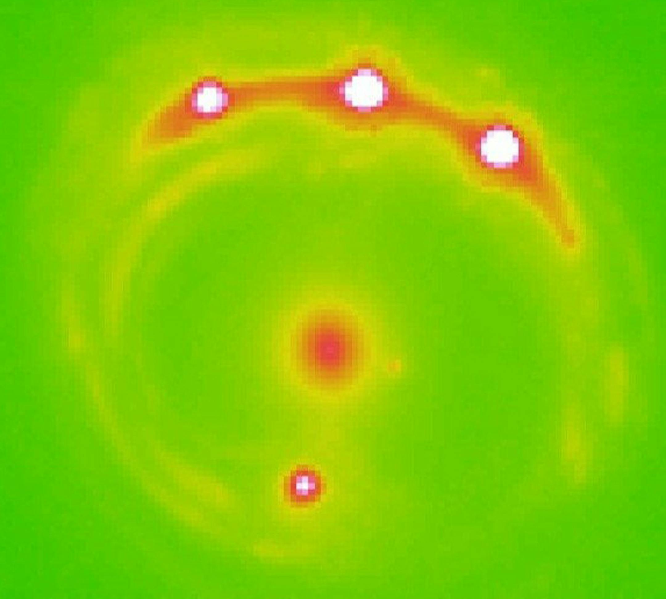 The lens galaxy, at center, and four lensed background quasars. MUST CREDIT: University of Oklahoma.