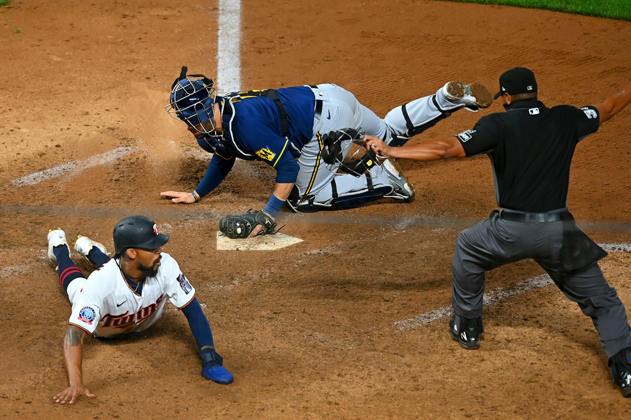 Minnesota Twins center fielder Byron Buxton (25) slid in safely to home as Milwaukee Brewers catcher Manny Pina (9) was late to the tag, earning the Twins a walk-off win in the bottom of the 12th inning.