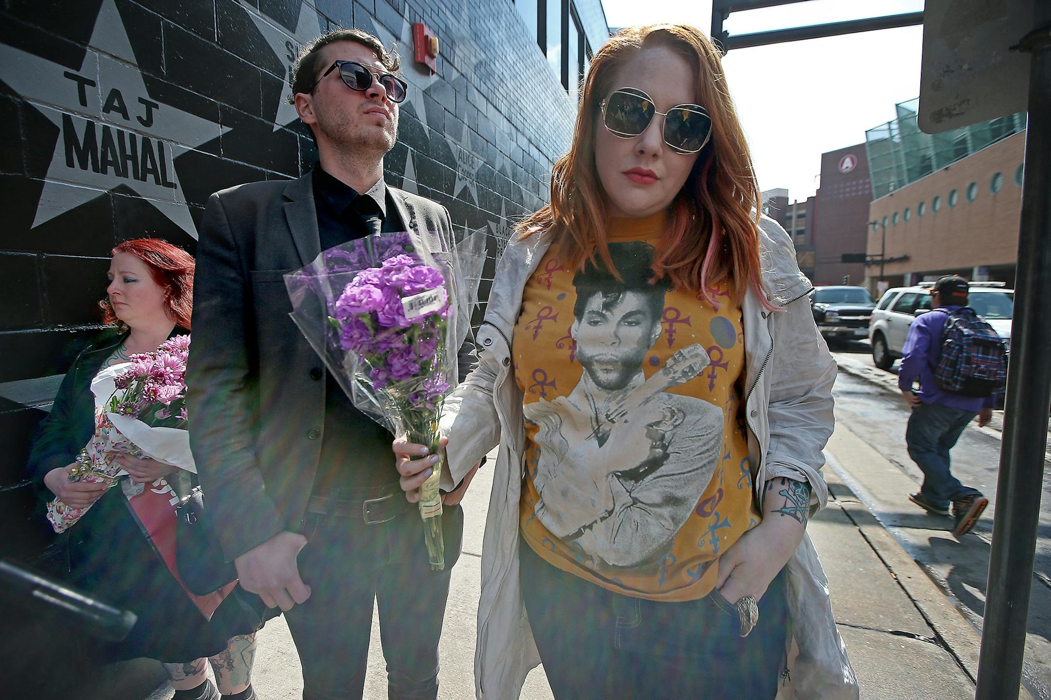 Aaron Johnson, cq, left, and Jen Boyles, cq, made their way to leave flowers beneath Prince's star at First Avenue after news of his death was made, Thursday, April 21, 2016 in Minneapolis, MN.