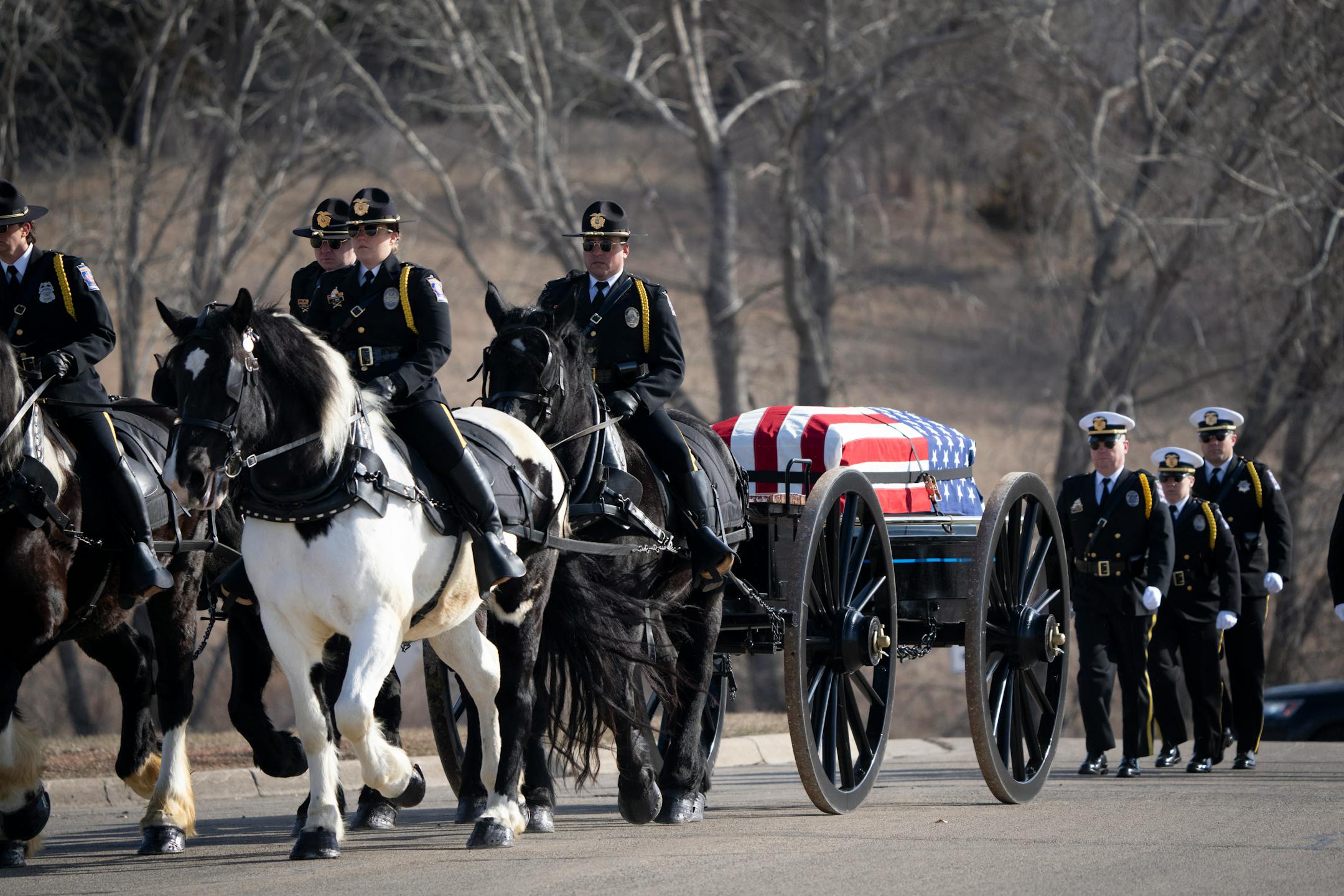 The caisson procession for Pope County deputy Josh Owen, who was fatally shot while responding to a domestic disturbance call a week ago, arrives at the funeral and visitation at Minnewaska Area High School in Glenwood, Minn., on Saturday, April 22, 2023