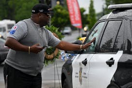 Paul King, a driver for Metro Transit, fights back tears while visiting a memorial for Minneapolis police officer Jamal Mitchell Friday afternoon outs