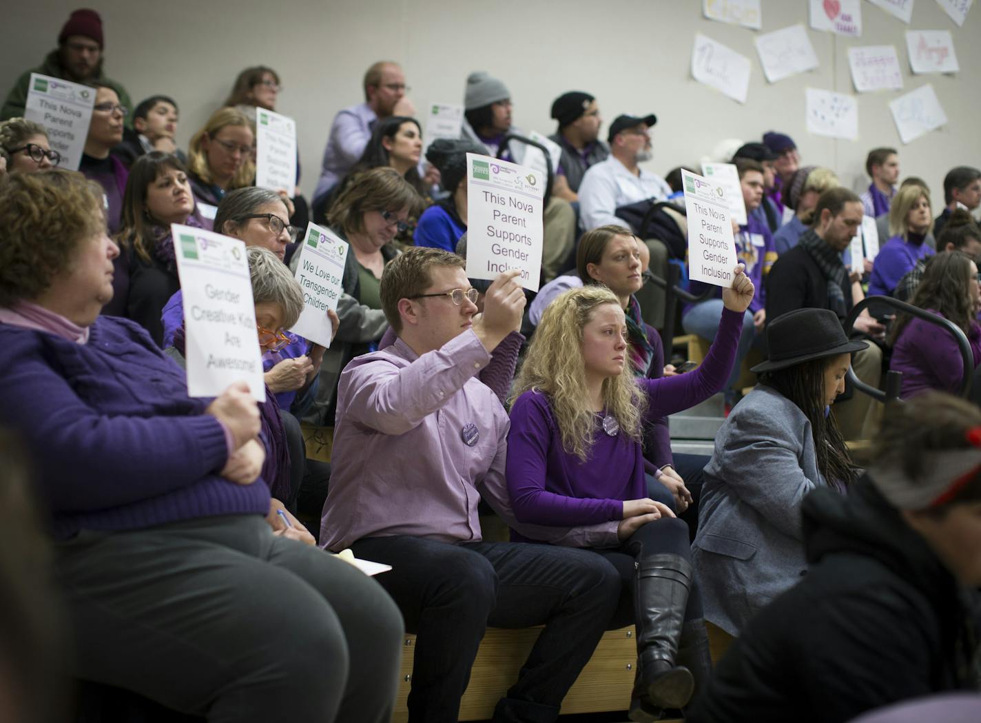 Dave and Hannah Edwards (in center holding hands), the parents of a gender nonconforming child at Nova Classical Academy, sat with signs in silent protest during a talk by Autumn Leva the Minnesota Family Council called Title IX and Gender Identity on Tuesday, January 12, 2015, in St. Paul, Minn.] RENEE JONES SCHNEIDER &#x2022; reneejones@startribune.com