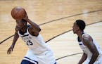 Minnesota Timberwolves guard Jimmy Butler (23) moved the ball down the court in front of fellow guard Jeff Teague (0) in the second quarter Saturday. 