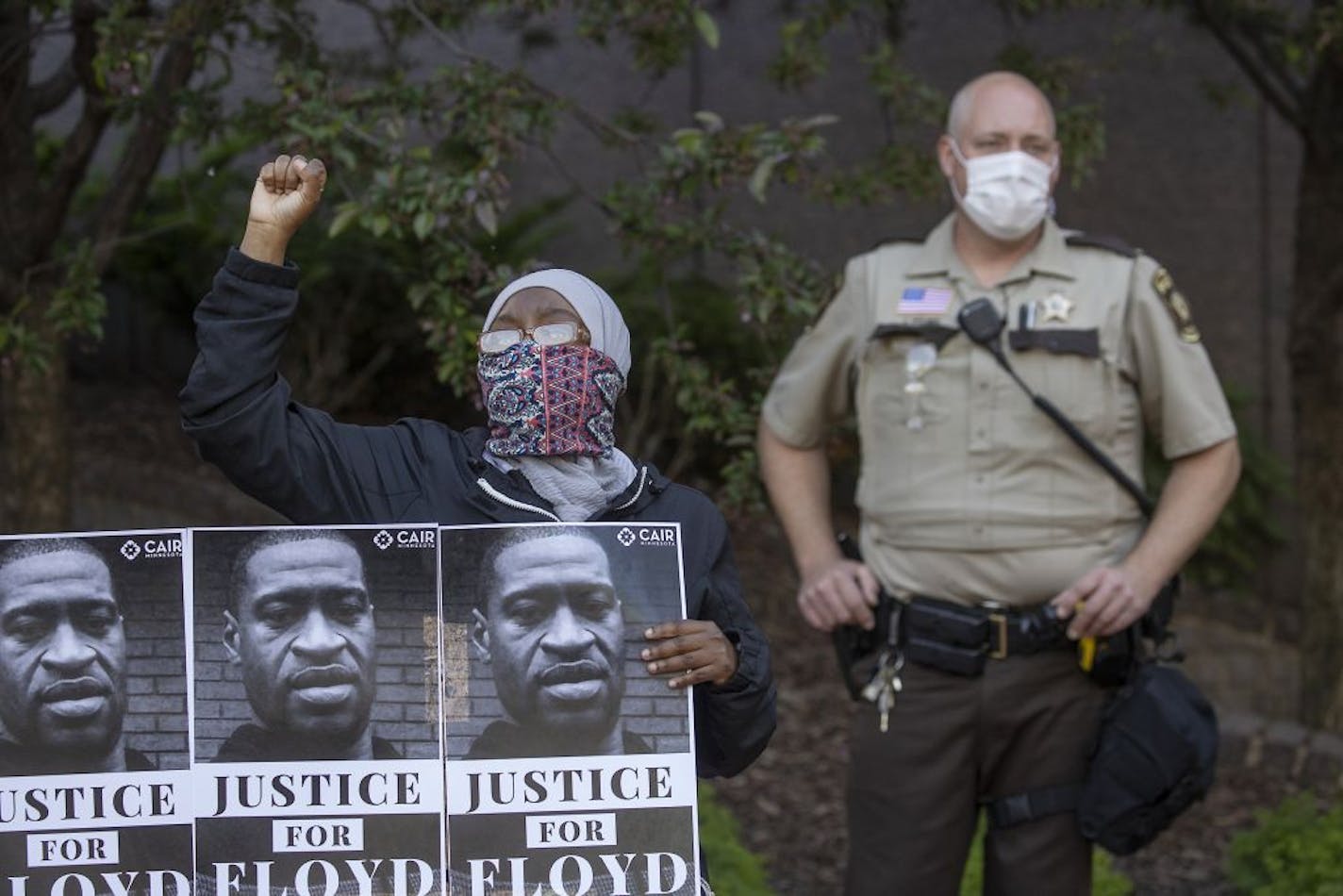 A protester holds a sign during a demonstration at the Government Center in support of the Minnesota chapter of the Council on American-Islamic Relations' call for the arrest of the police involved in Monday's death of George Floyd, Thursday, May 28, 2020, in Minneapolis.