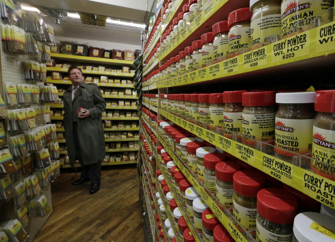 In this Nov. 21, 2013 photo, a man shops wall after wall dried herbs and spices, nearly all of them imported, processed and packaged by Kalustyan's, at Kalustyan's Indian/Middle Eastern spice and specialty food shop in New York. The not-so-little gem of a shop nestled into a row of like-minded stores on Lexington Avenue is known to New Yorker foodies, but off the map for most tourists. (AP Photo/Richard Drew) ORG XMIT: NYRD207