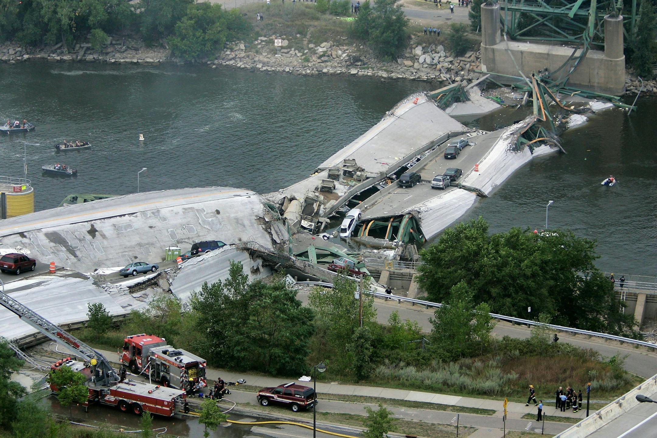 This view shows the Interstate 35W freeway bridge over the Mississippi River after it collapsed Wednesday, Aug. 1, 2007, in Minneapolis, as emergency crews gather. The bridge collapsed during evening rush hour sending vehicles, tons of concrete and twisted metal crashing into the water.