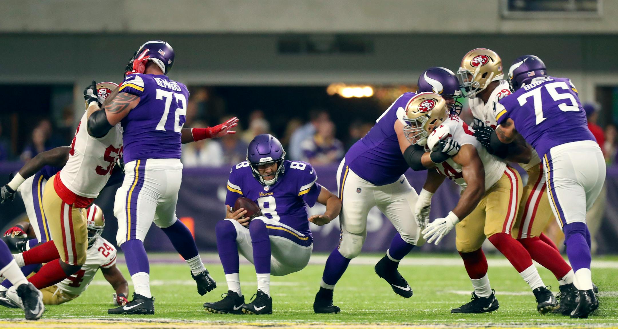 Minnesota Vikings quarterback Sam Bradford (8) was sacked for an eight yard loss by San Francisco 49ers defensive end Elvis Dumervil (58) in the first quarter.