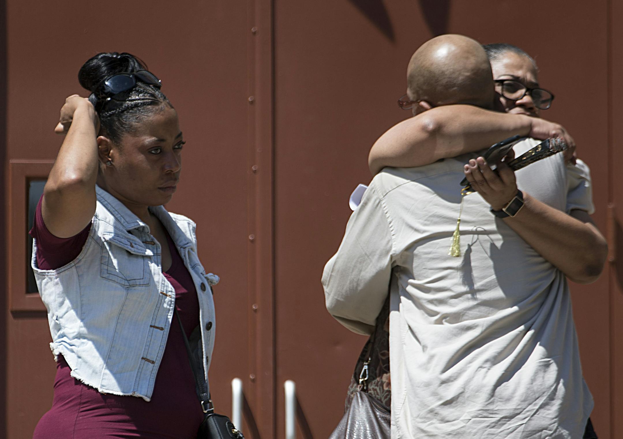 Mourners embrace one another for support atop the church steps in the middle of the service. ] ALEX KORMANN • alex.kormann@startribune.com The funeral for Thurman Blevins, 31, a black man shot and killed by Minneapolis Police on June 23rd, was held at Faith Deliverance Holiness Church on Saturday, July 14, 2018. Hundreds of mourners gathered in the church to pray and chant in Blevins' memory. The service was two hours long after which the casket was brought to Crystal Lake Cemetery.