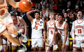 Senior standout Isaac Asuma has one foot on the raised floor of Williams Arena, ready to join the celebration, as he watches the final seconds of Cher