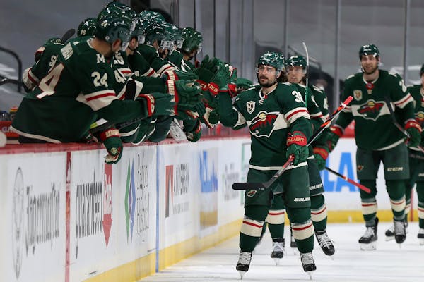 Wild's Mats Zuccarello high fives teammate on the bench in celebration after his goal against the San Jose Sharks