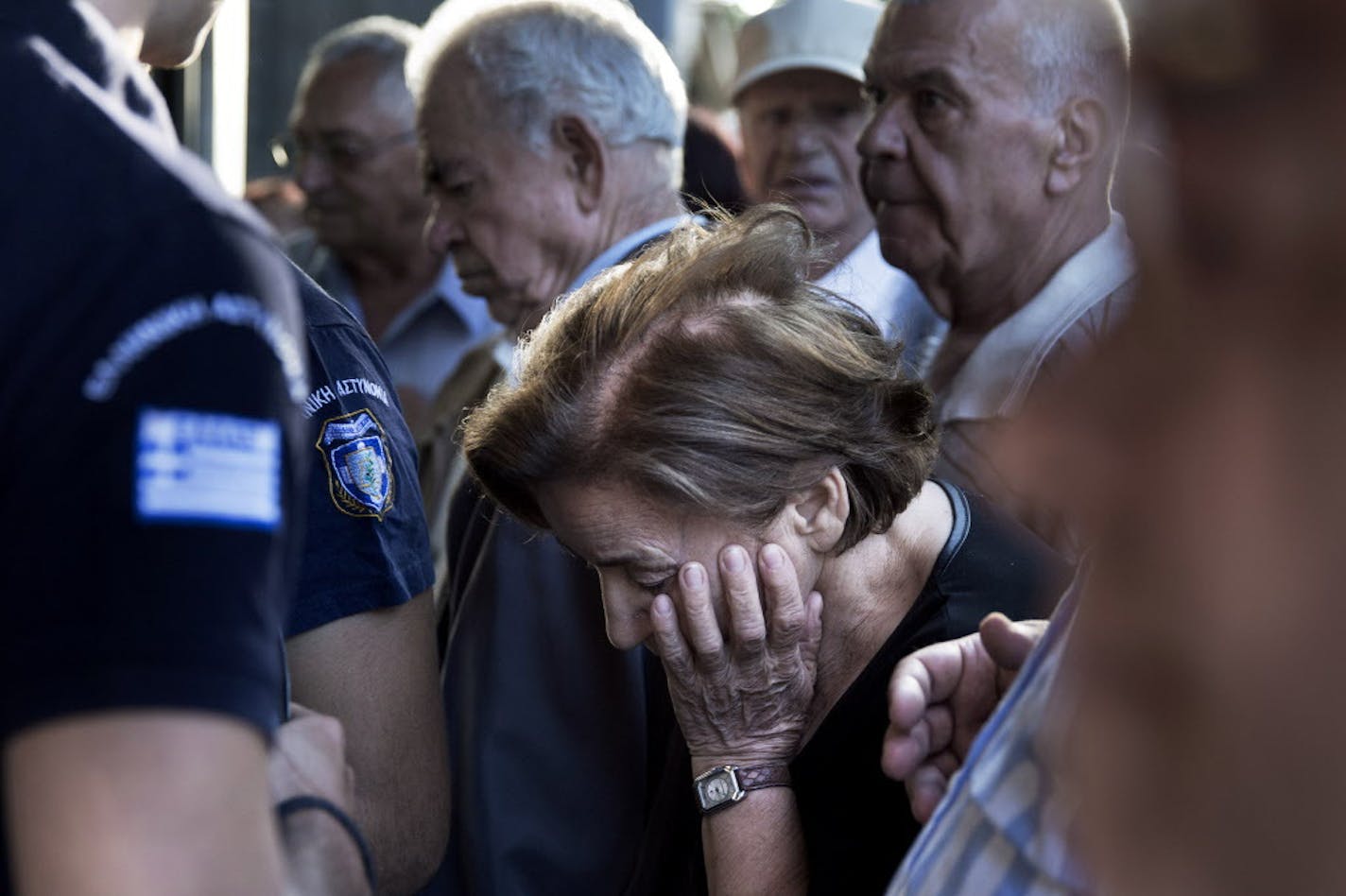 Pensioners crowd the entrance of bank in Athens, Wednesday, July 1, 2015. Long lines formed as bank branches around the country were ordered by Greece's government to reopen Wednesday to help desperate pensioners without ATM cards cash up to 120 euros ($134) from their retirement checks. (AP Photo/Petros Giannakouris)