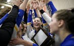 Wayzata players, including middle hitter Lily Emlong (24), center, celebrated with their trophy Thursday night.