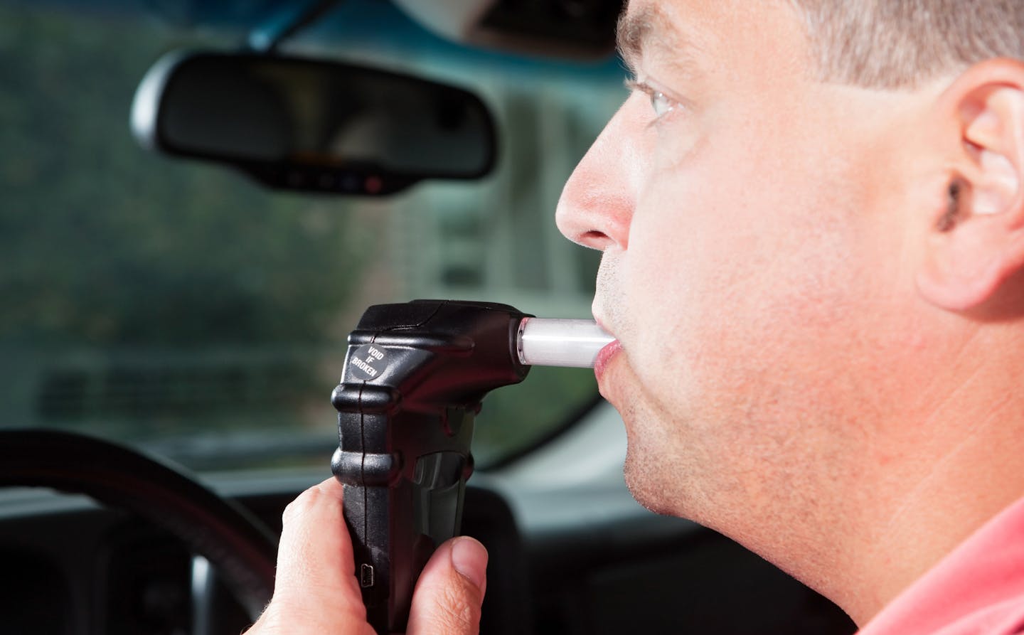 iStock
A male driver is blowing into an ignition interlock system which checks his alcohol concentration before allowing the vehicle to be started. Ignition interlock devices may be an alternative sentence for drunk driving or a probation requirement for those who have received a DUI.