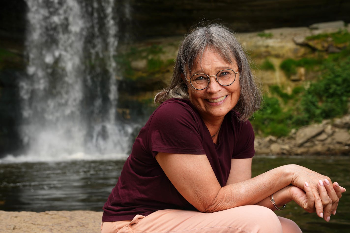 Karen Cooper, author of "When Minnehaha Flowed With Whiskey: A Spirited History," sits for a portrait Tuesday, July 12, 2022 at Minnehaha Falls in south Minneapolis. ] ANTHONY SOUFFLE • anthony.souffle@startribune.com