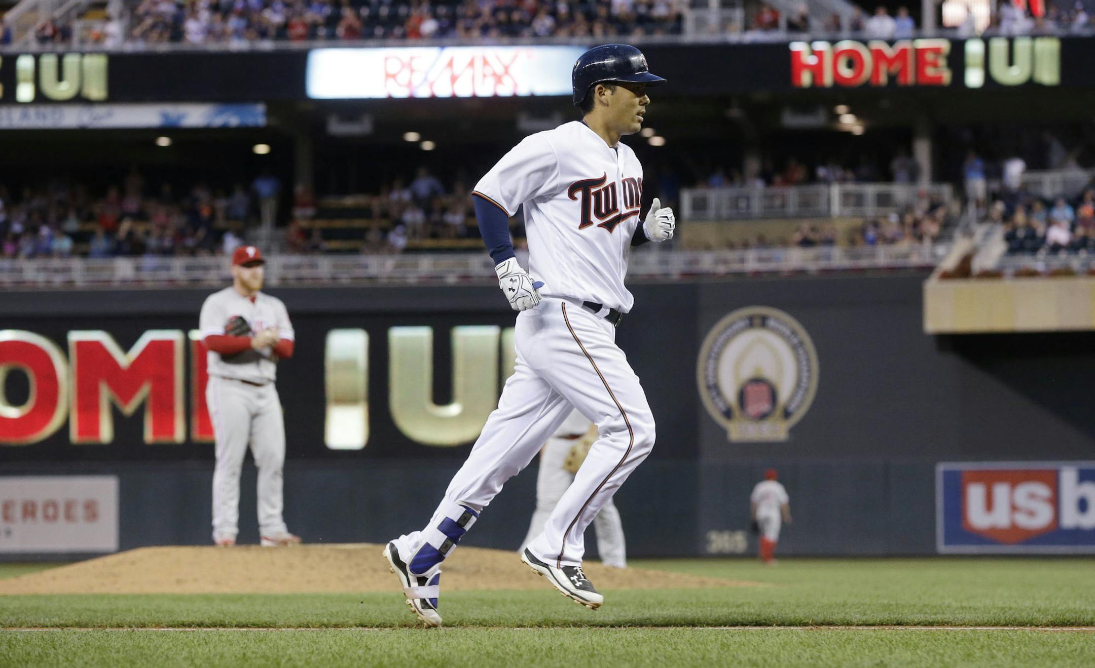 Minnesota Twins' Kurt Suzuki heads for home after his two-run home run off Philadelphia Phillies relief pitcher Brett Oberholtzer, background left, during the fifth inning of a baseball game Tuesday, June 21, 2016, in Minneapolis. (AP Photo/Jim Mone)