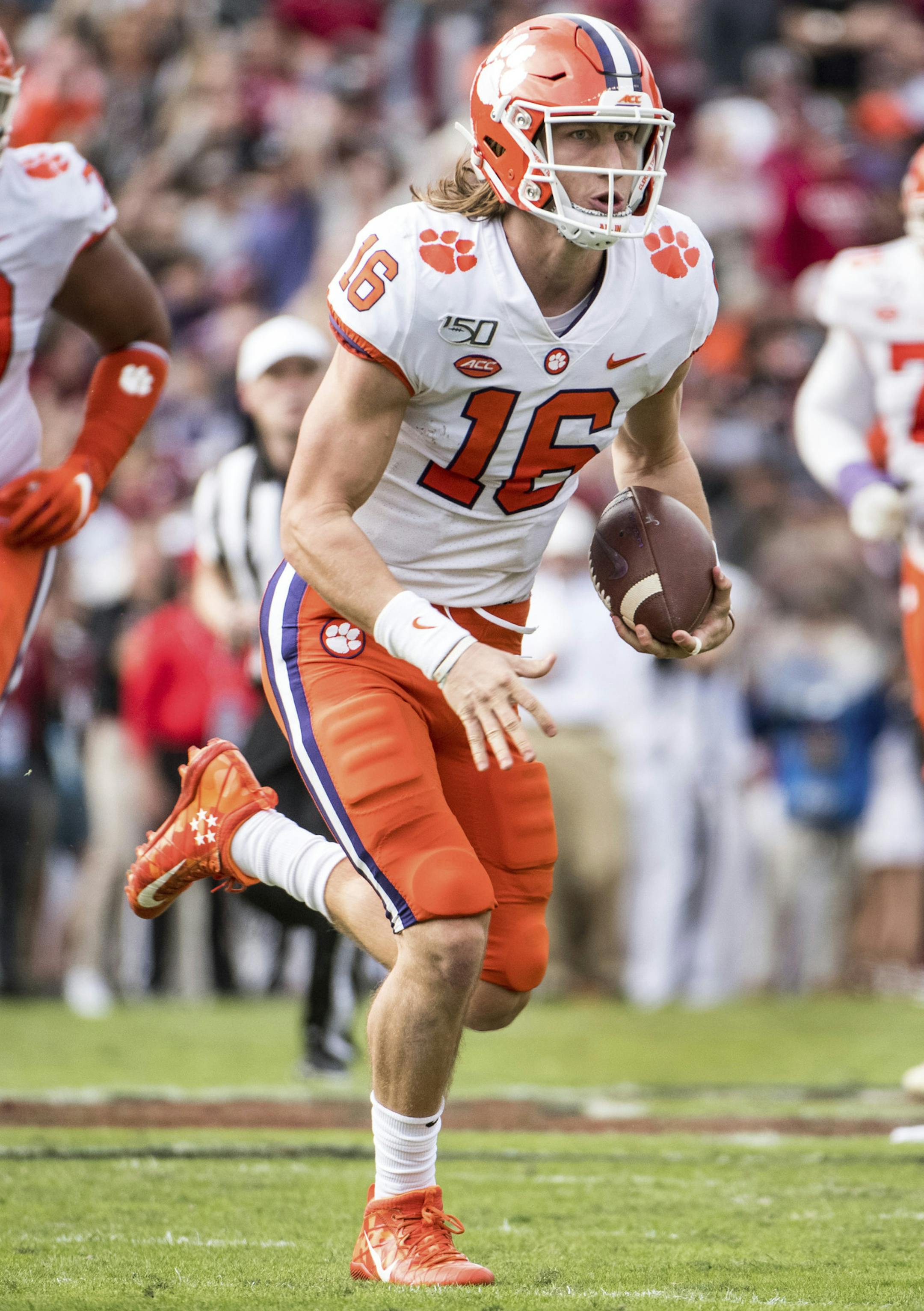 FILE - In this Nov. 30, 2019, file photo, Clemson quarterback Trevor Lawrence (16) carries the ball against South Carolina during the first half of an NCAA college football game, in Columbia, S.C. Heading into this year’s slate of conference title games a case could be made that No. 1 LSU (No. 2 CFP), No. 2 Ohio State (No. 1 CFP) and No. 3 Clemson (No. 3 CFP) have all done enough already to lose their conference championship games and still get in the College Football Playoff.(AP Photo/Se